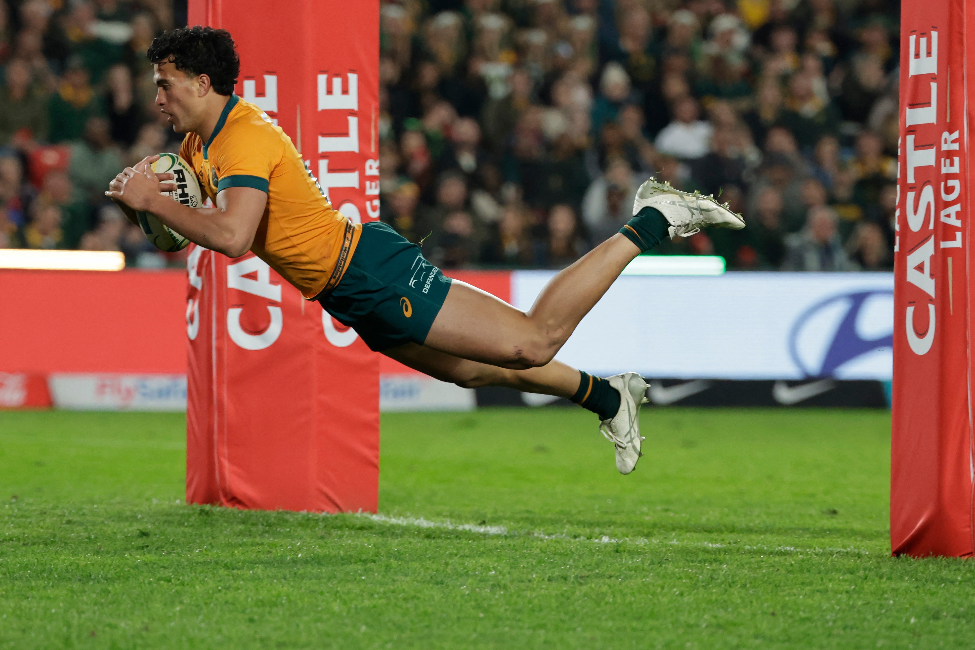 Australia's centre Joseph Aukuso-Suaalii dives across the line