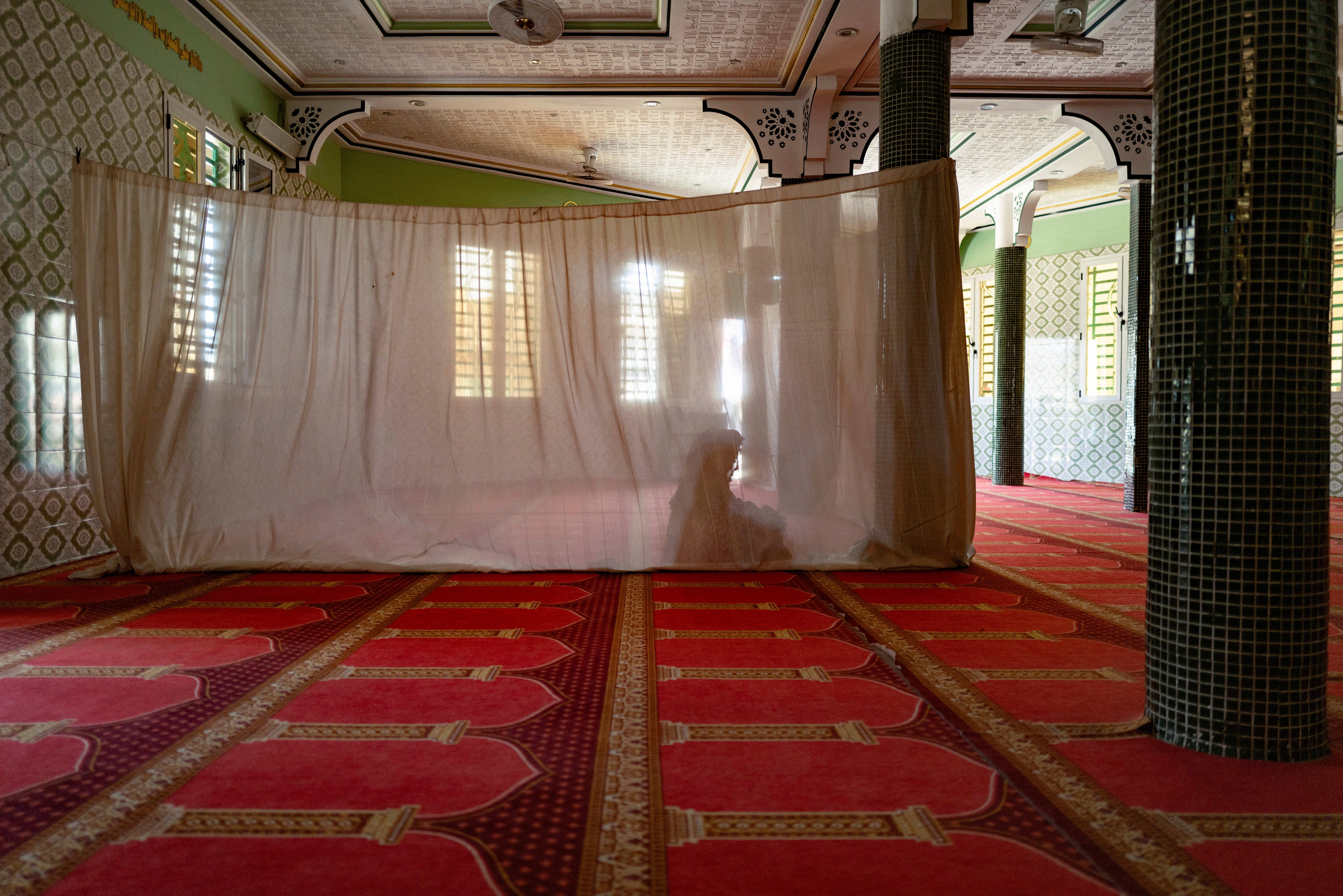 A woman prays in the designated women's section at the Great Mosque of Nietty Mbar in Thiaroye