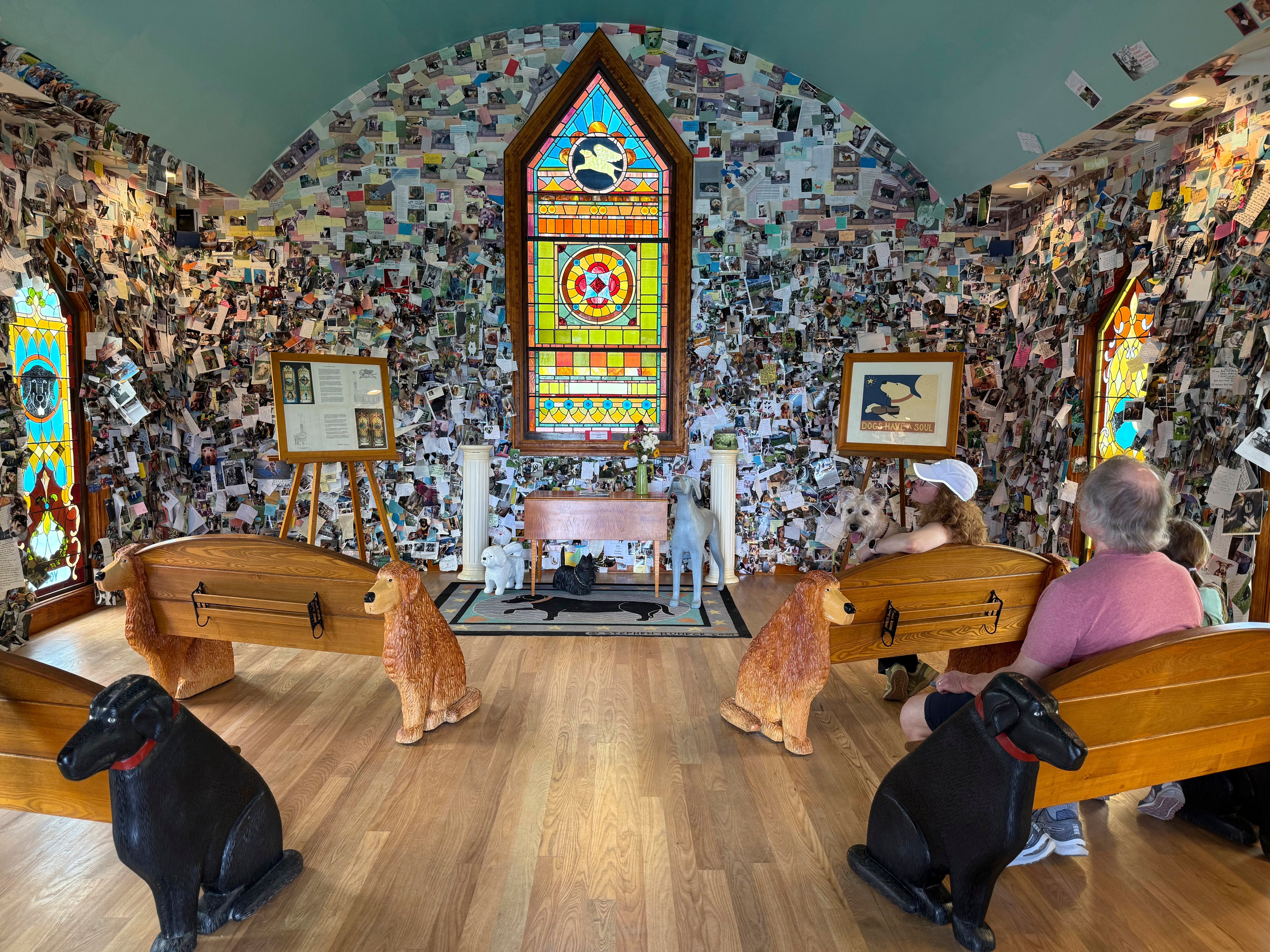 Visitors sit in the Dog Chapel at Dog Mountain, a 150-acre dog park created by Vermont folk artist Stephen Huneck, Thursday, Aug. 7, 2025, in St. Johnsbury, Vt. (AP Photo/Amanda Swinhart)