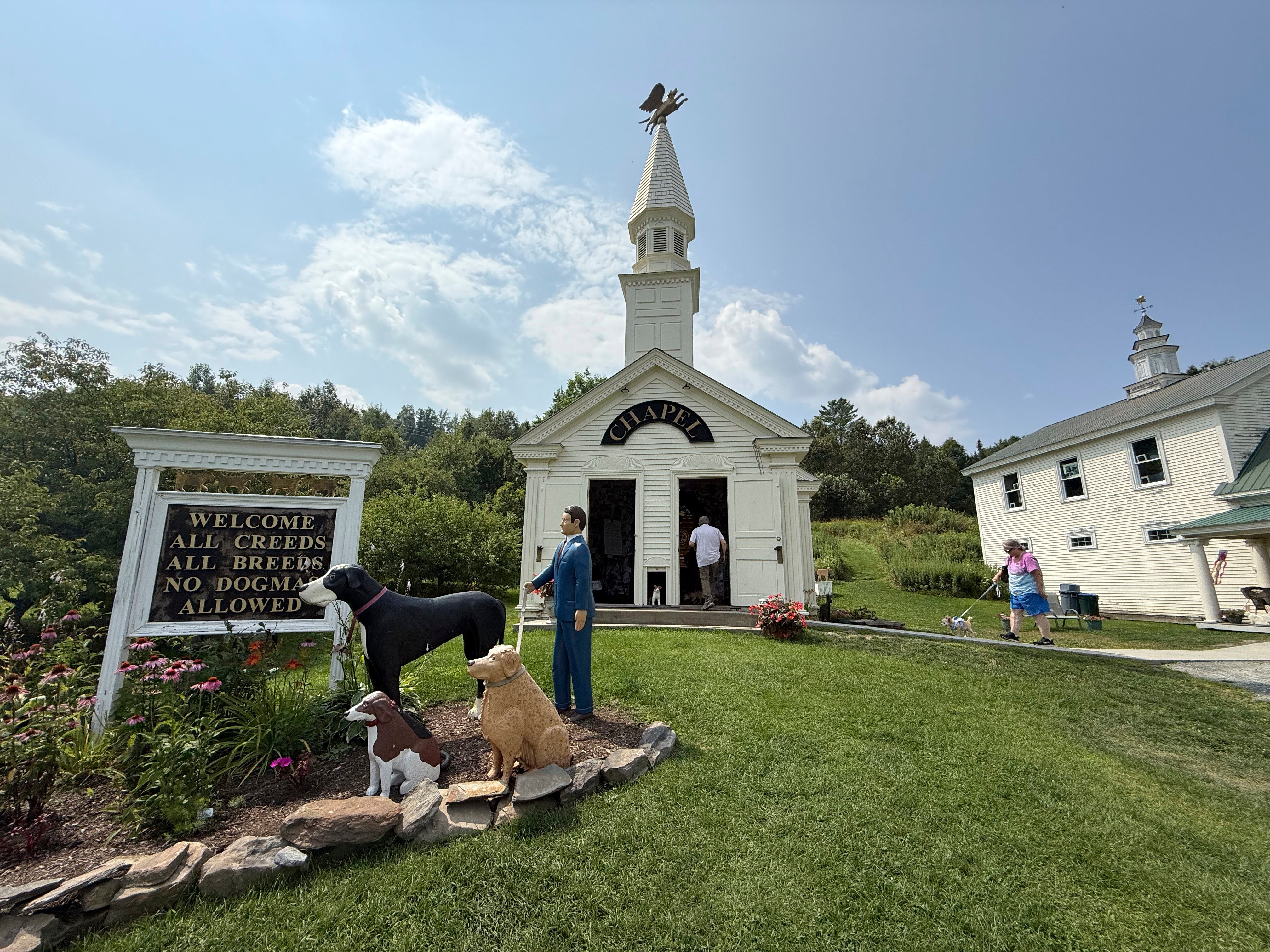 Visitors enter the Dog Chapel at Dog Mountain, a 150-acre dog park created by Vermont folk artist Stephen Huneck, Thursday, Aug. 7, 2025, in St. Johnsbury, Vt. (AP Photo/Amanda Swinhart)