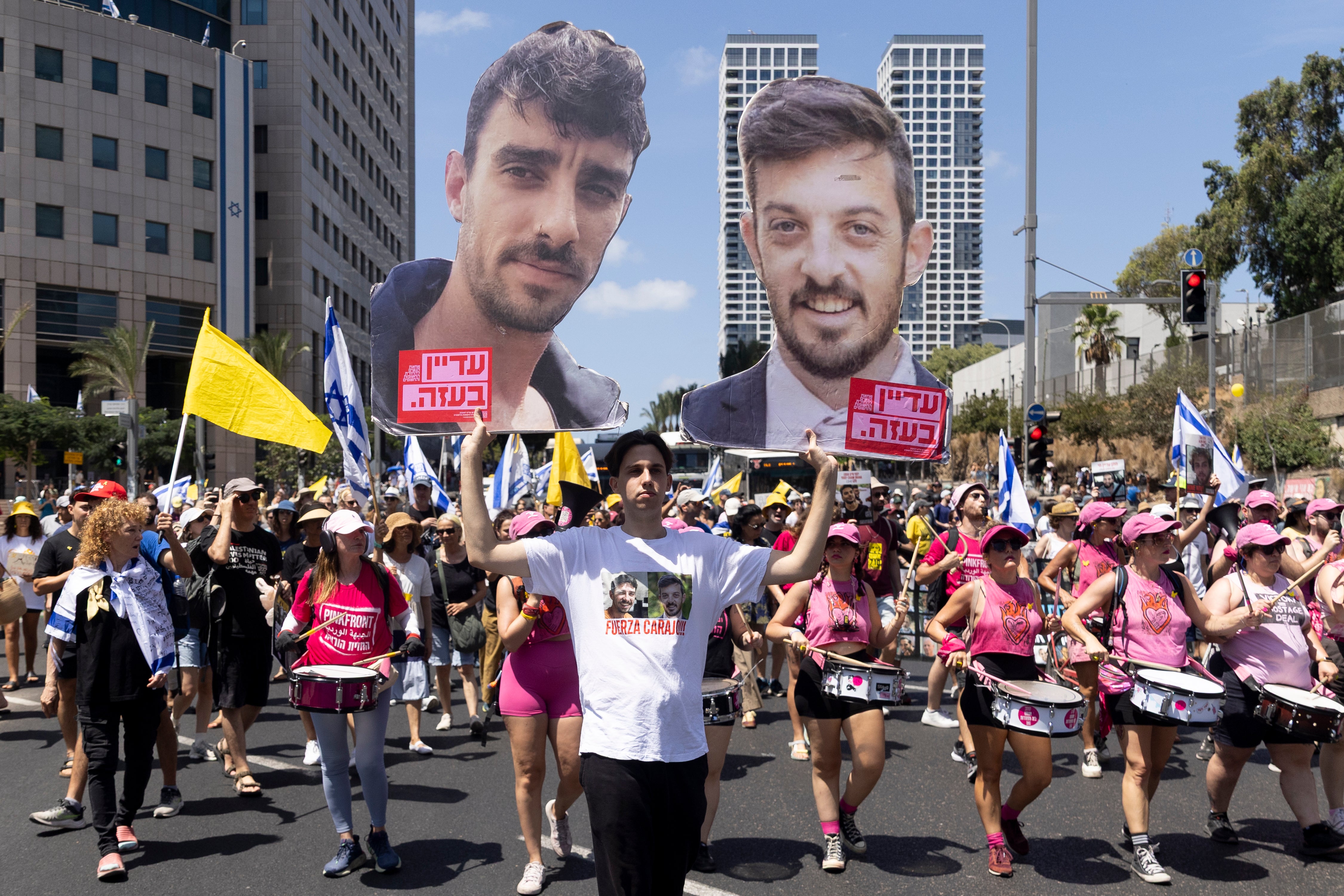 Protesters hold photos of hostages during the demonstration in Tel Aviv