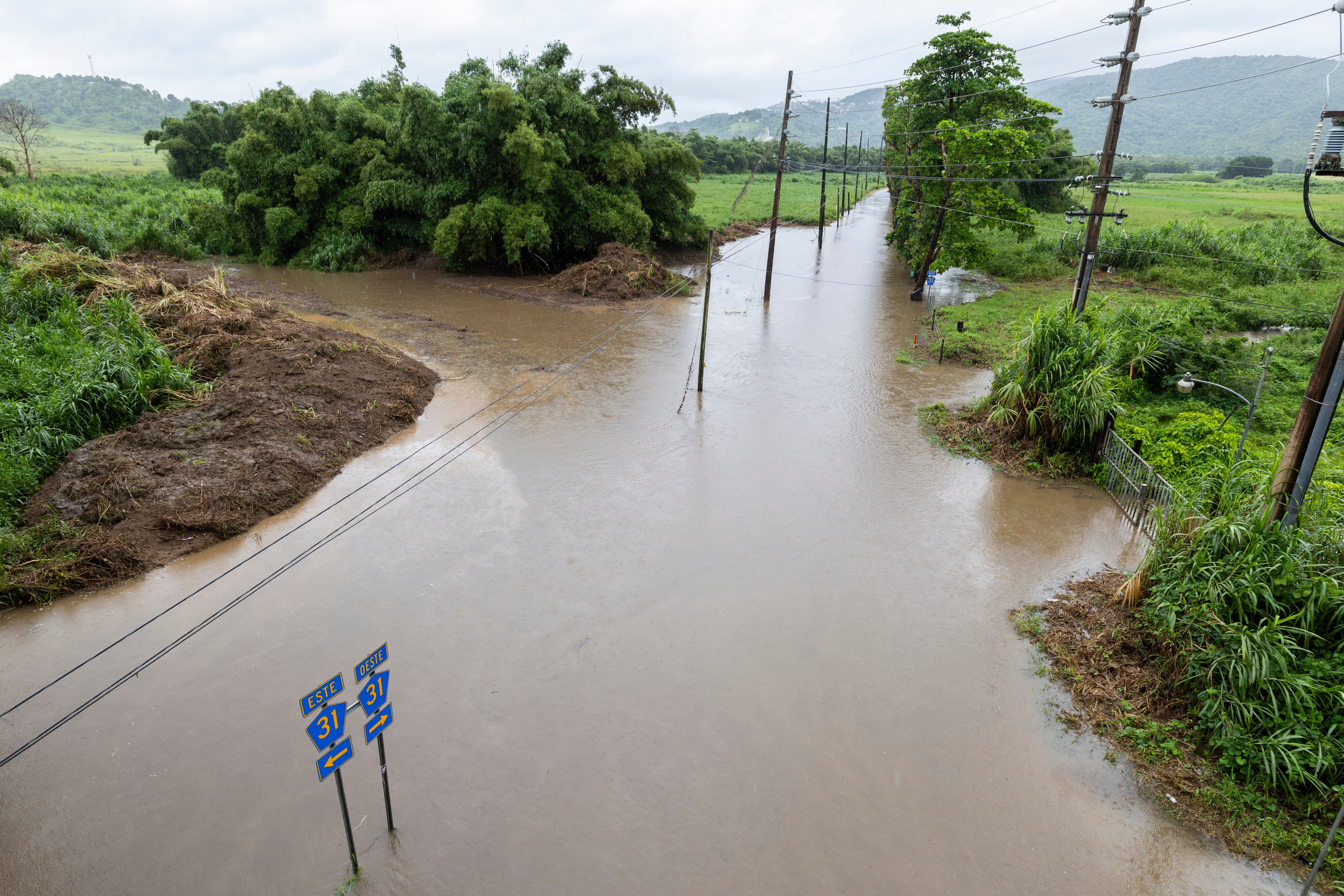 Water floods a road in Naguabo, Puerto Rico, as Hurricane Erin brings rain to the island, Sunday, Aug. 17, 2025