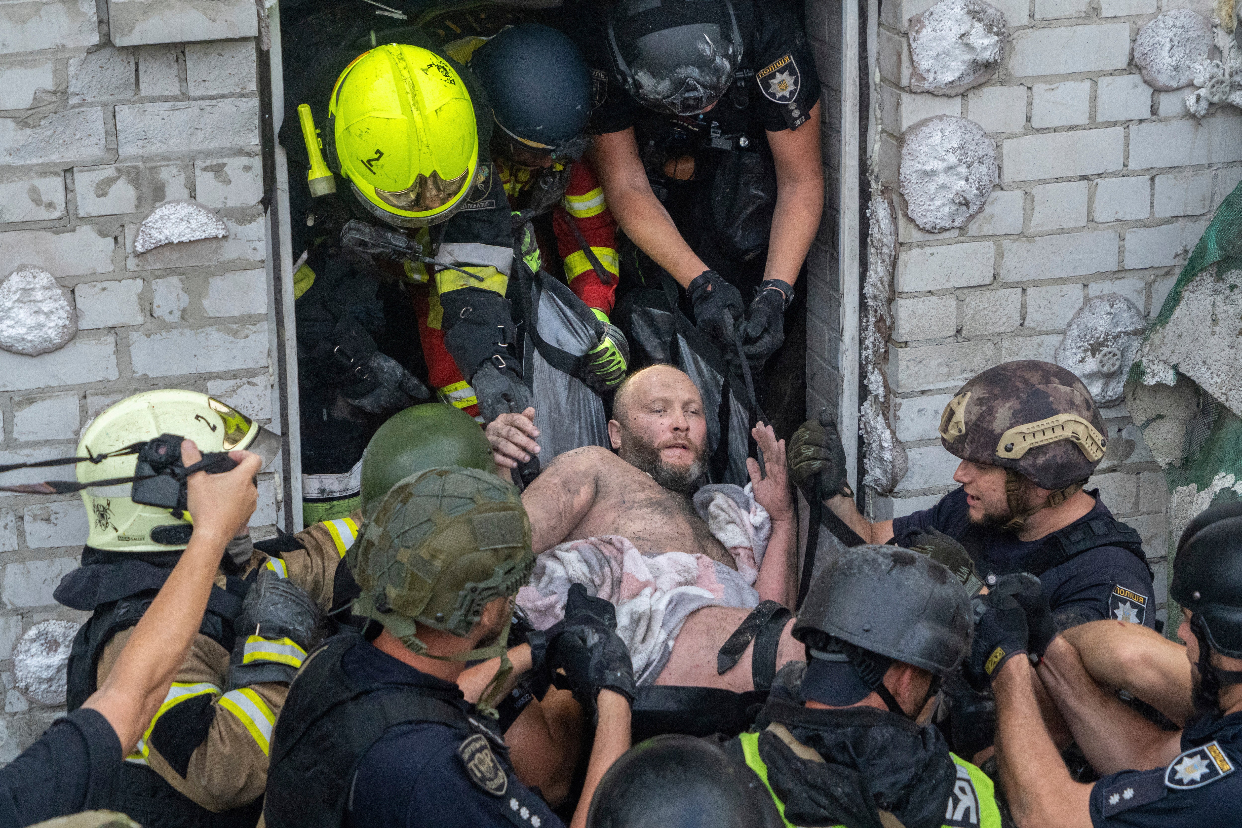 Rescuers evacuate an injured civilian after a residential building was hit following Russia's missile attack in Kharkiv, Ukraine, Monday, Aug. 18, 2025