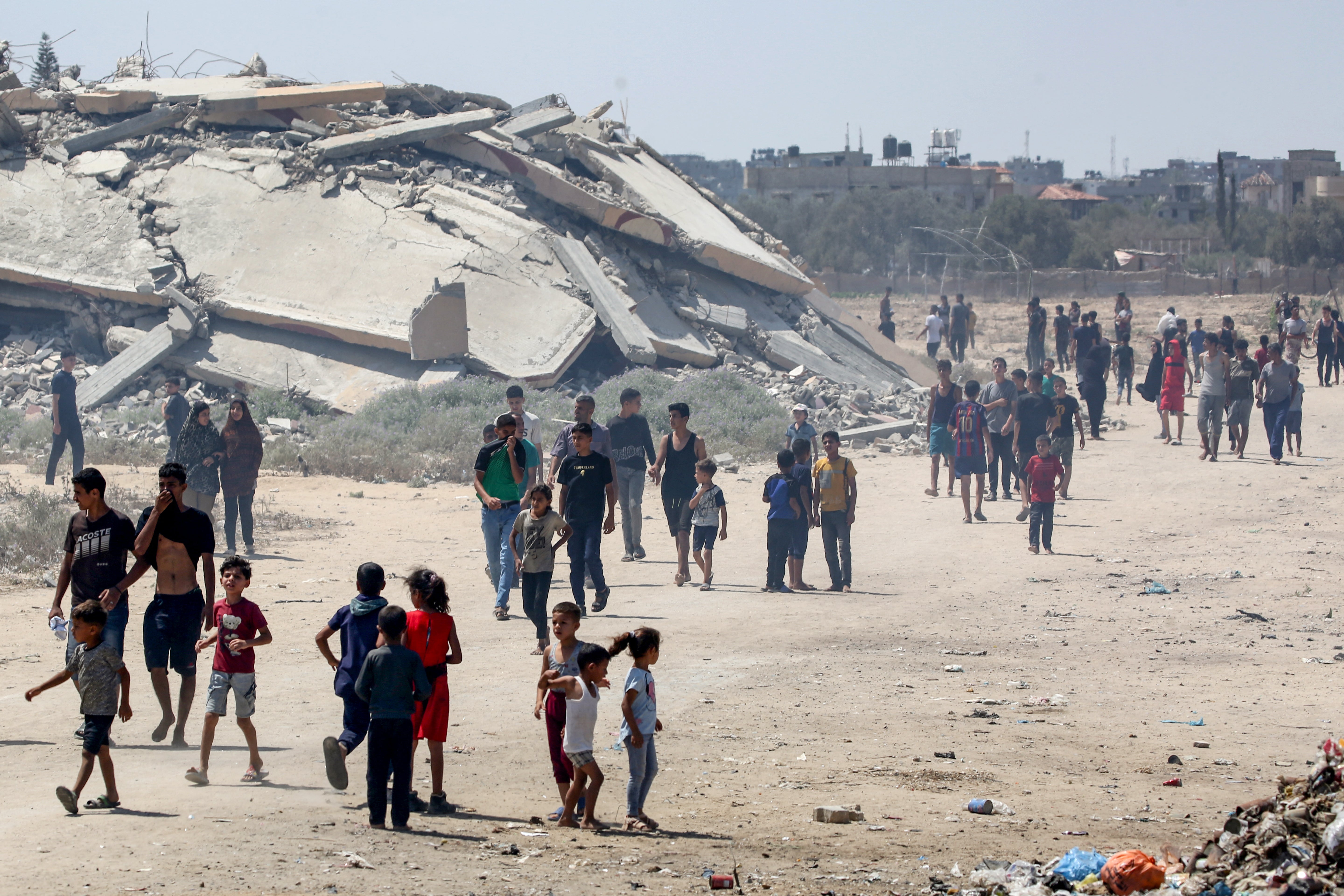 Displaced Palestinians make their way towards the site of a humanitarian aid airdrop at the Bureij camp in the central Gaza Strip