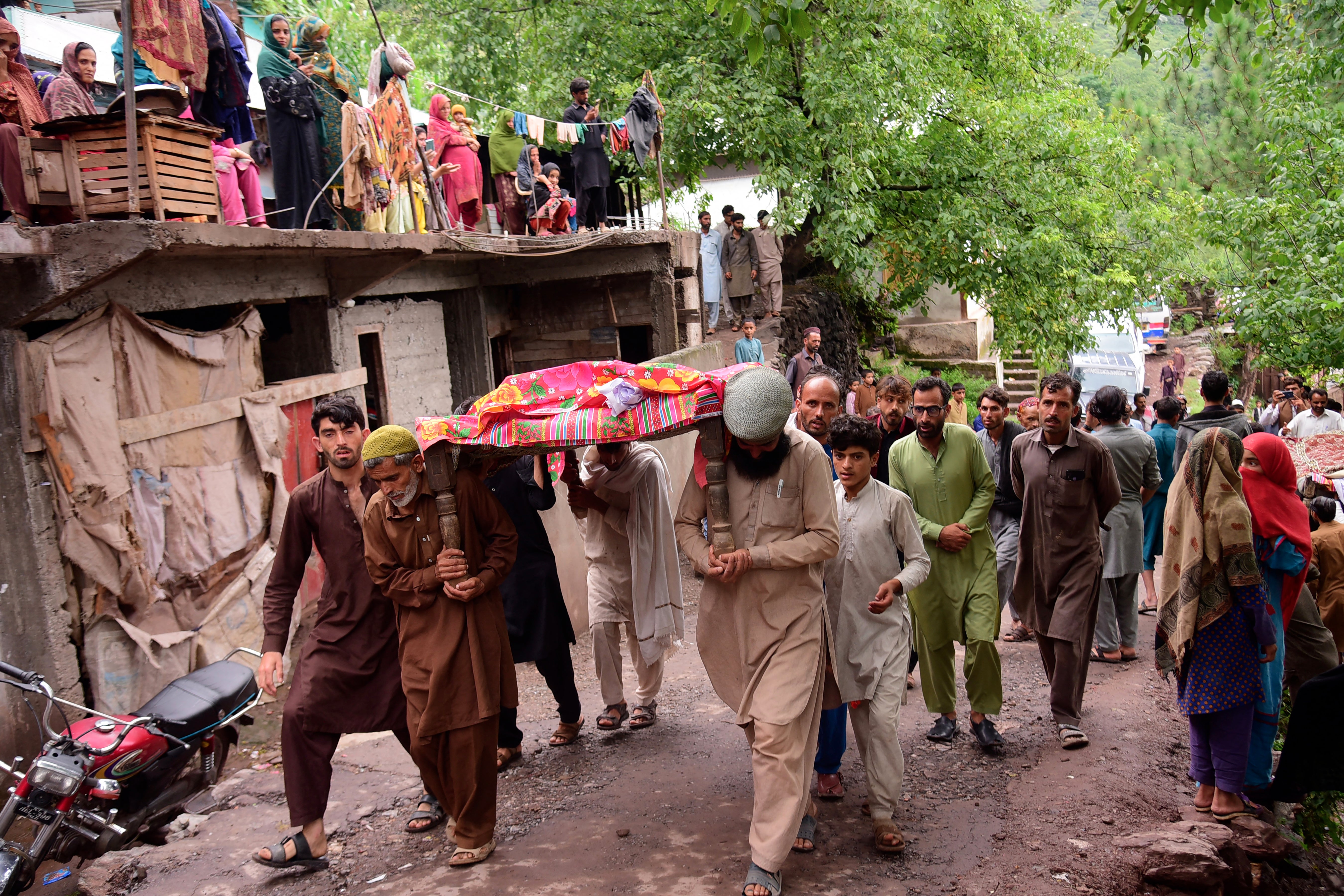 Mourners carry a coffin of a flood affected victim after flash floods in Naryean Behaak village some 36kms north from Muzaffarabad