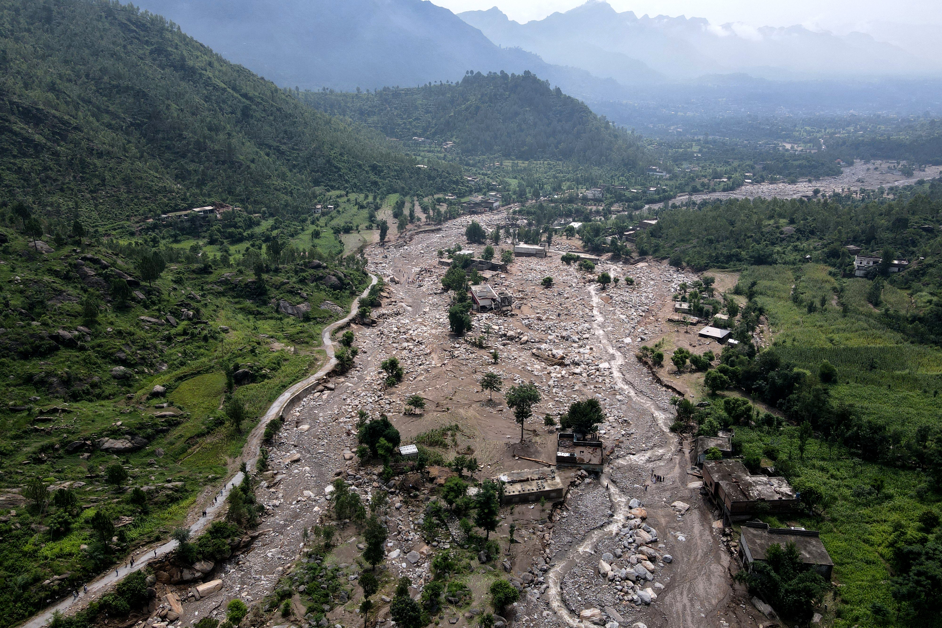 An aerial view shows houses partially submerged in sludge along a riverbed in the aftermath of flash floods at the Buner district of mountainous Khyber Pakhtunkhwa province