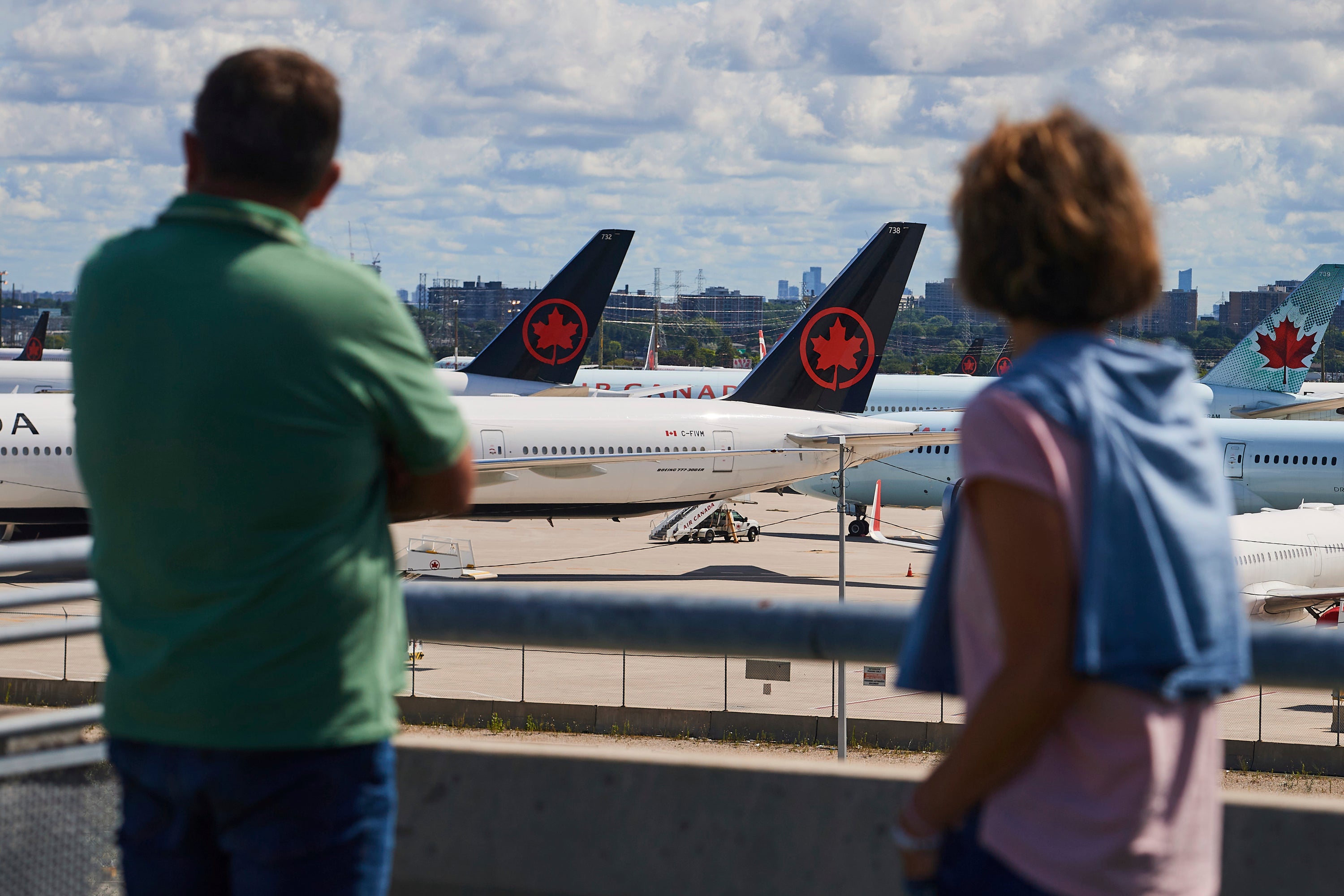 Travelers look out over grounded Air Canada planes as flight attendants picket at Pearson International Airport in Toronto
