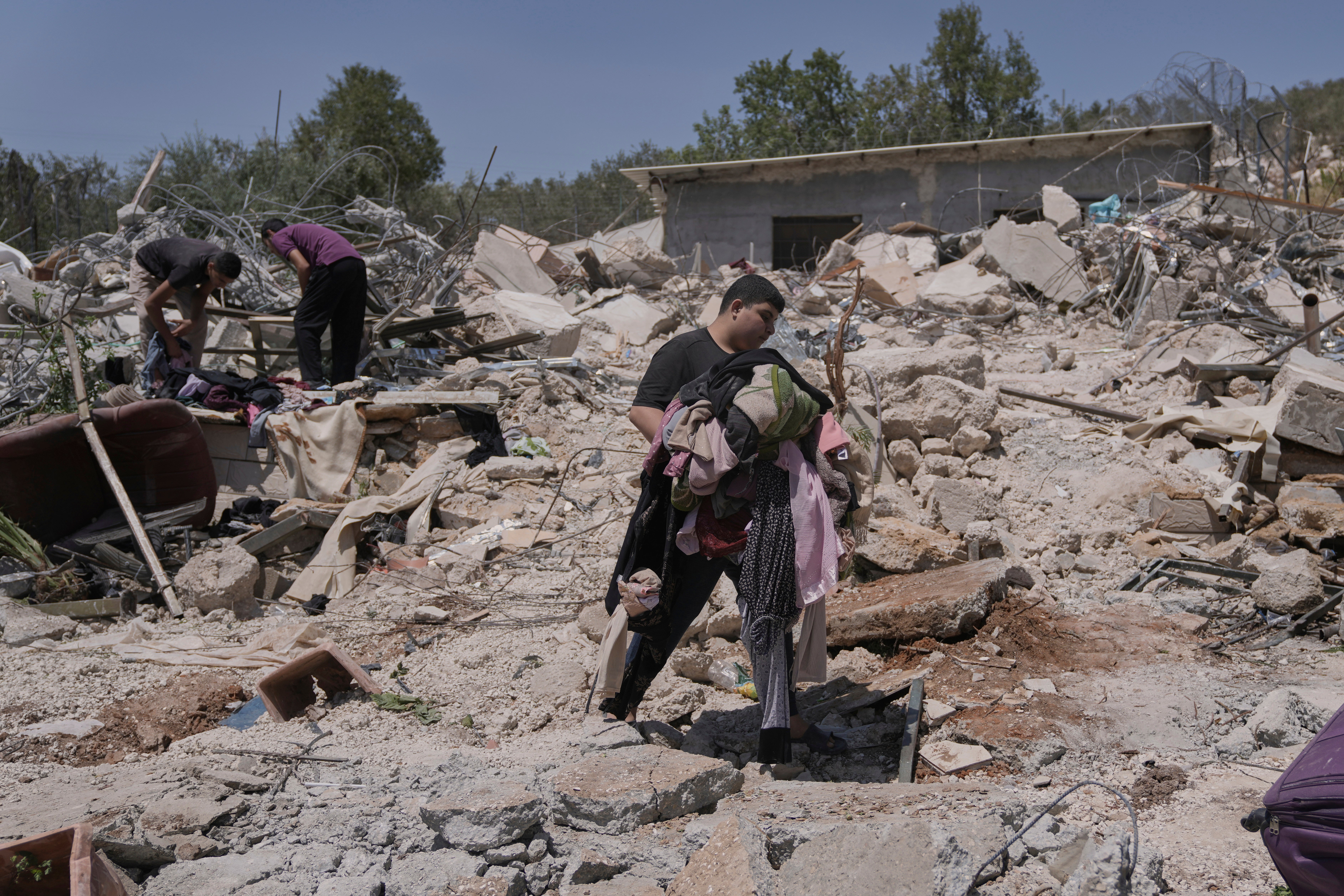 A Palestinian youth walks over the rubble of a house demolished by the Israeli army in the West Bank