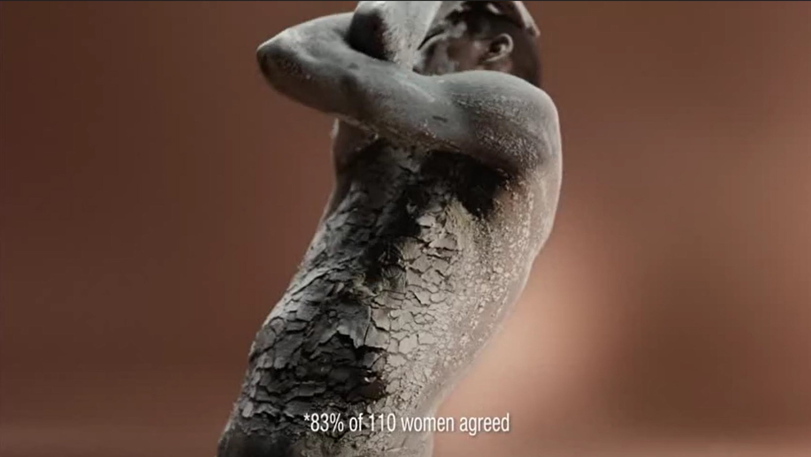 In one section a Black person is shown covered in a cracked, clay-like material