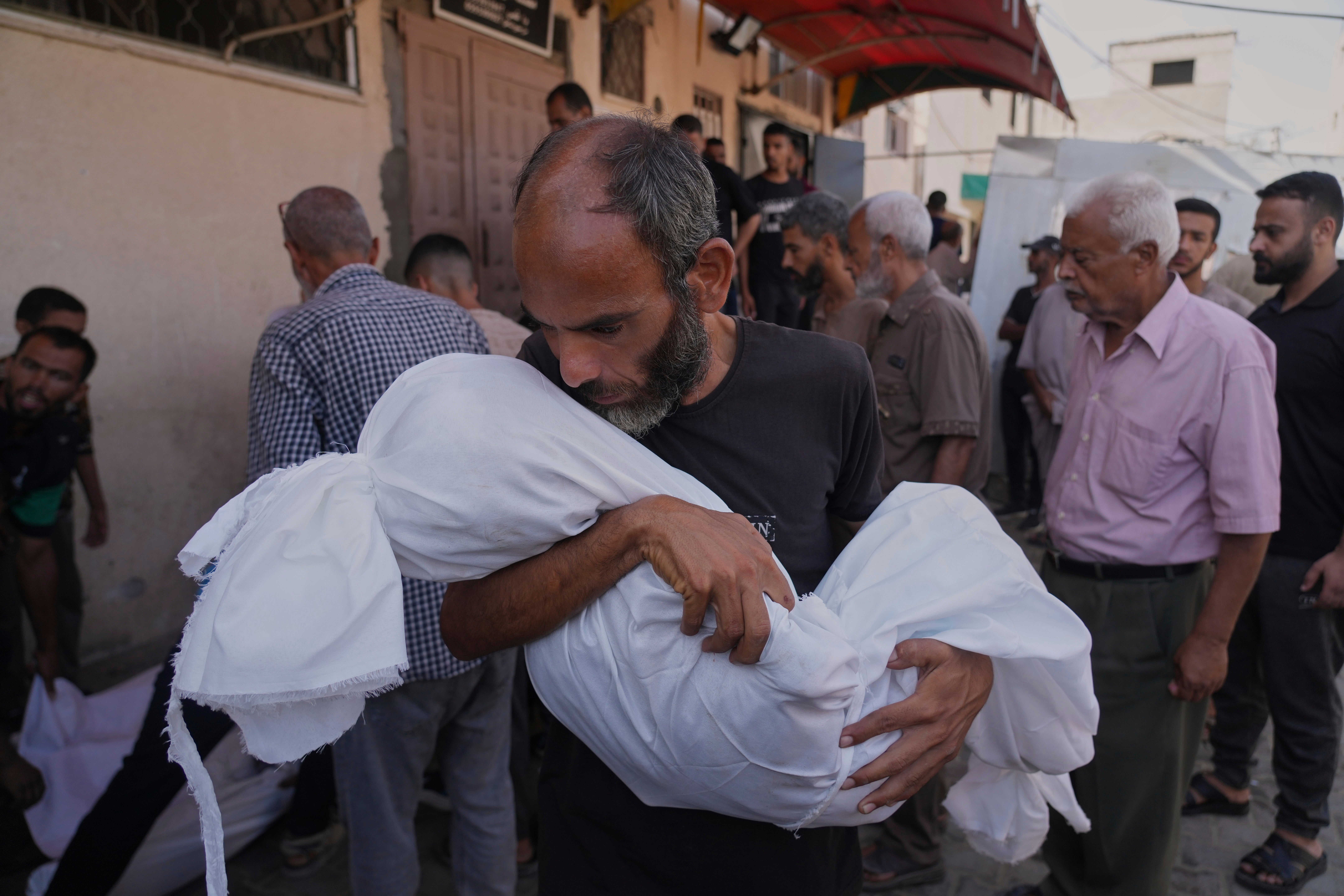 Ahmed al-Hajj carries the body of his daughter, Dana, 13, who was killed in an Israeli airstrike in Gaza on Tuesday