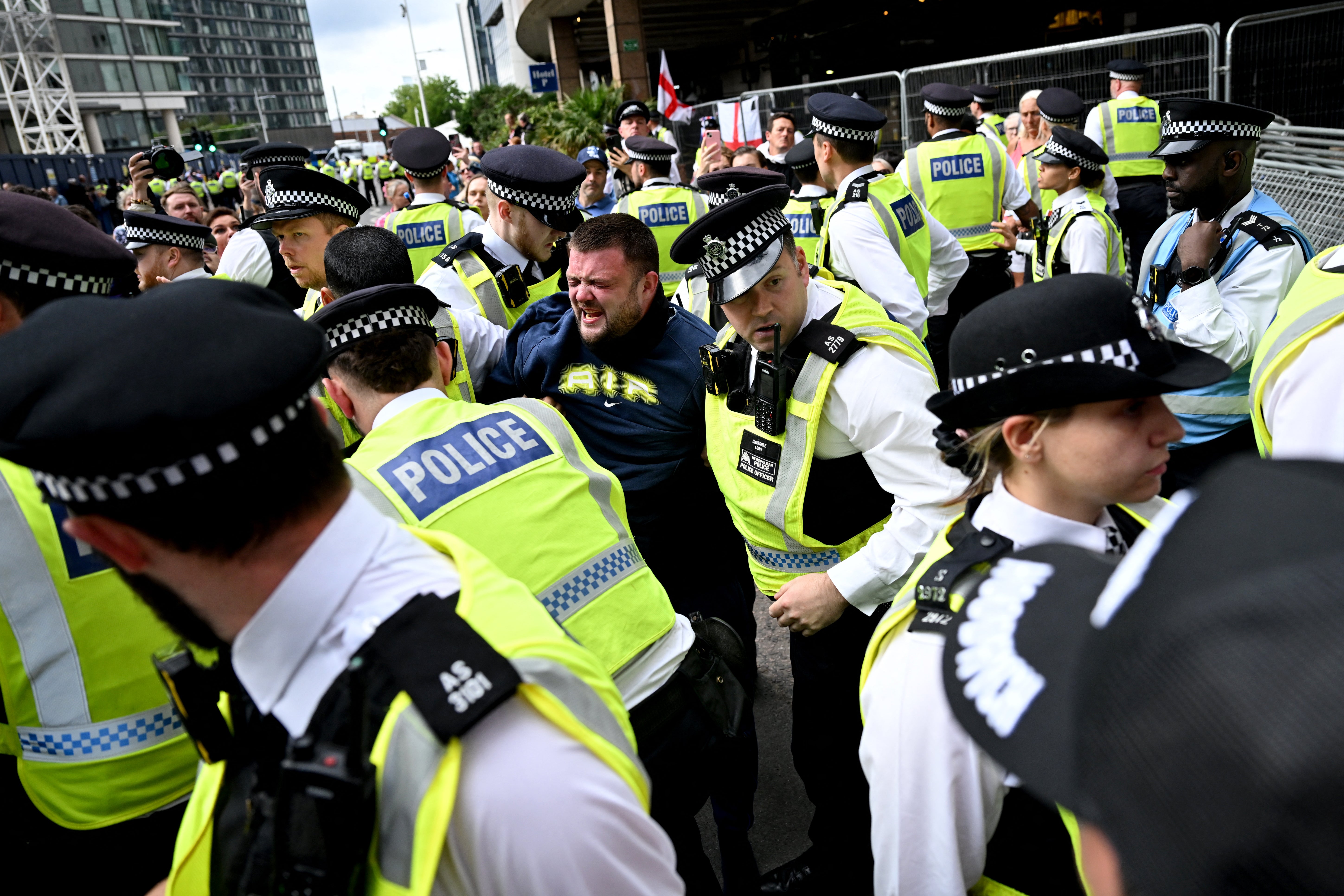 A man reacts after being arrested during a demonstration outside the Britannia Hotel in Canary Wharf on August 3, 2025 over it’s use to house asylum seekers.