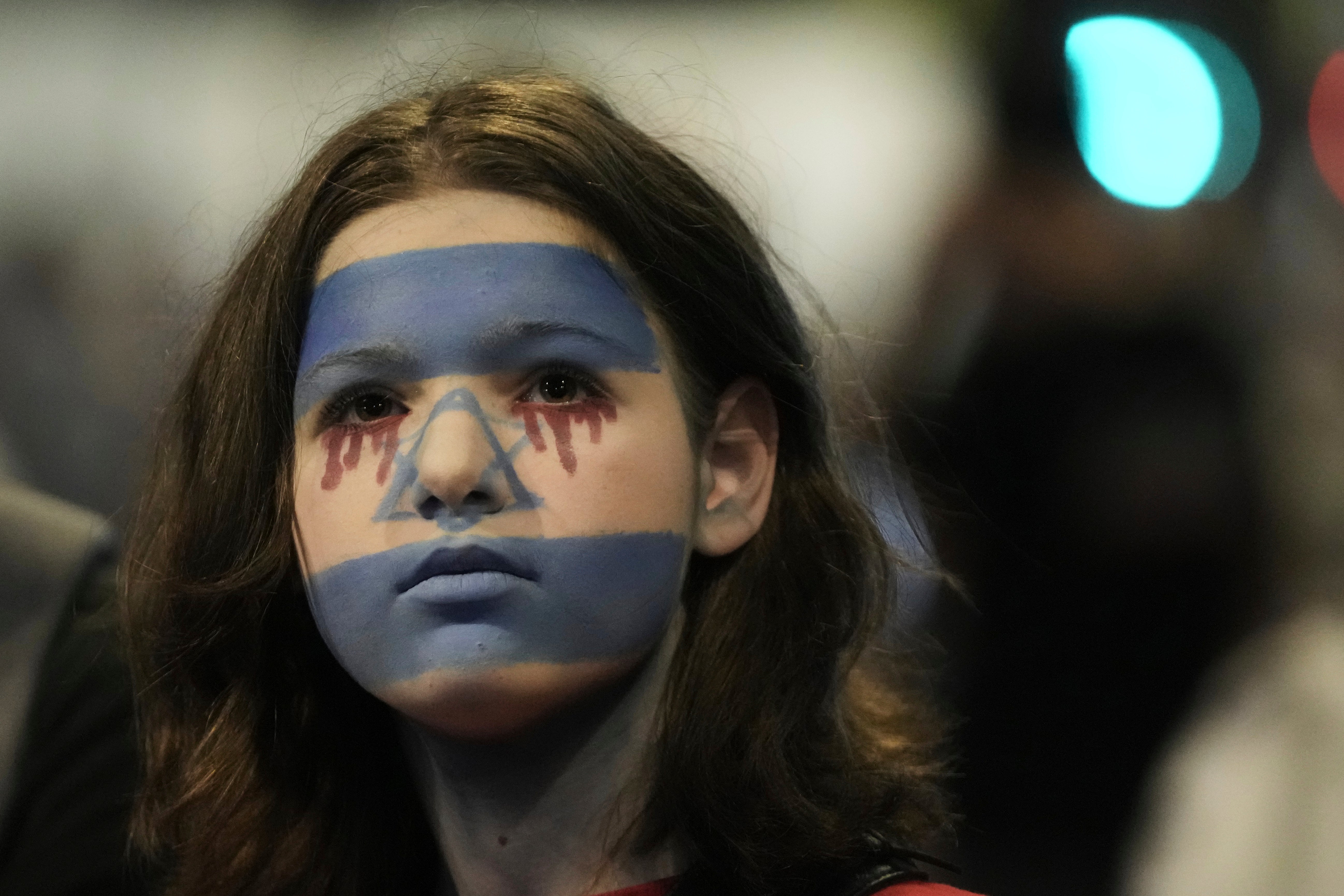 A woman with her face painted with Israeli flag protest in Tel Aviv against Benjamin Netanyahu's government