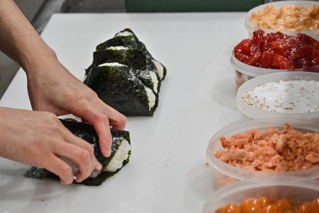 <p>File. A staff member making rice balls, known as ‘onigiri’, at a restaurant in the Otsuka area of Tokyo, Japan</p>