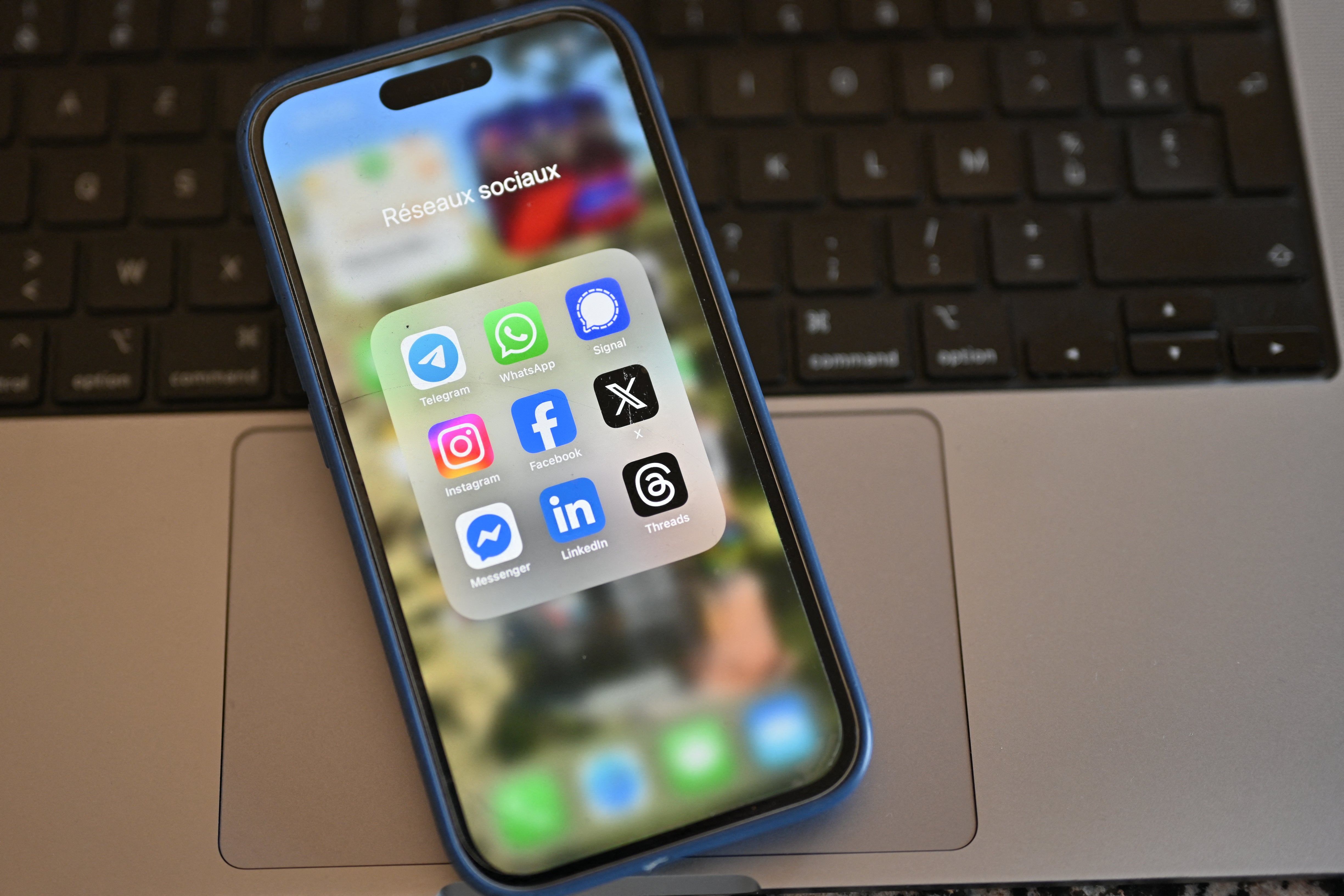 View of a mobile phone displaying social media apps such as Telegram, Signal, Instagram, X and LinkedIn