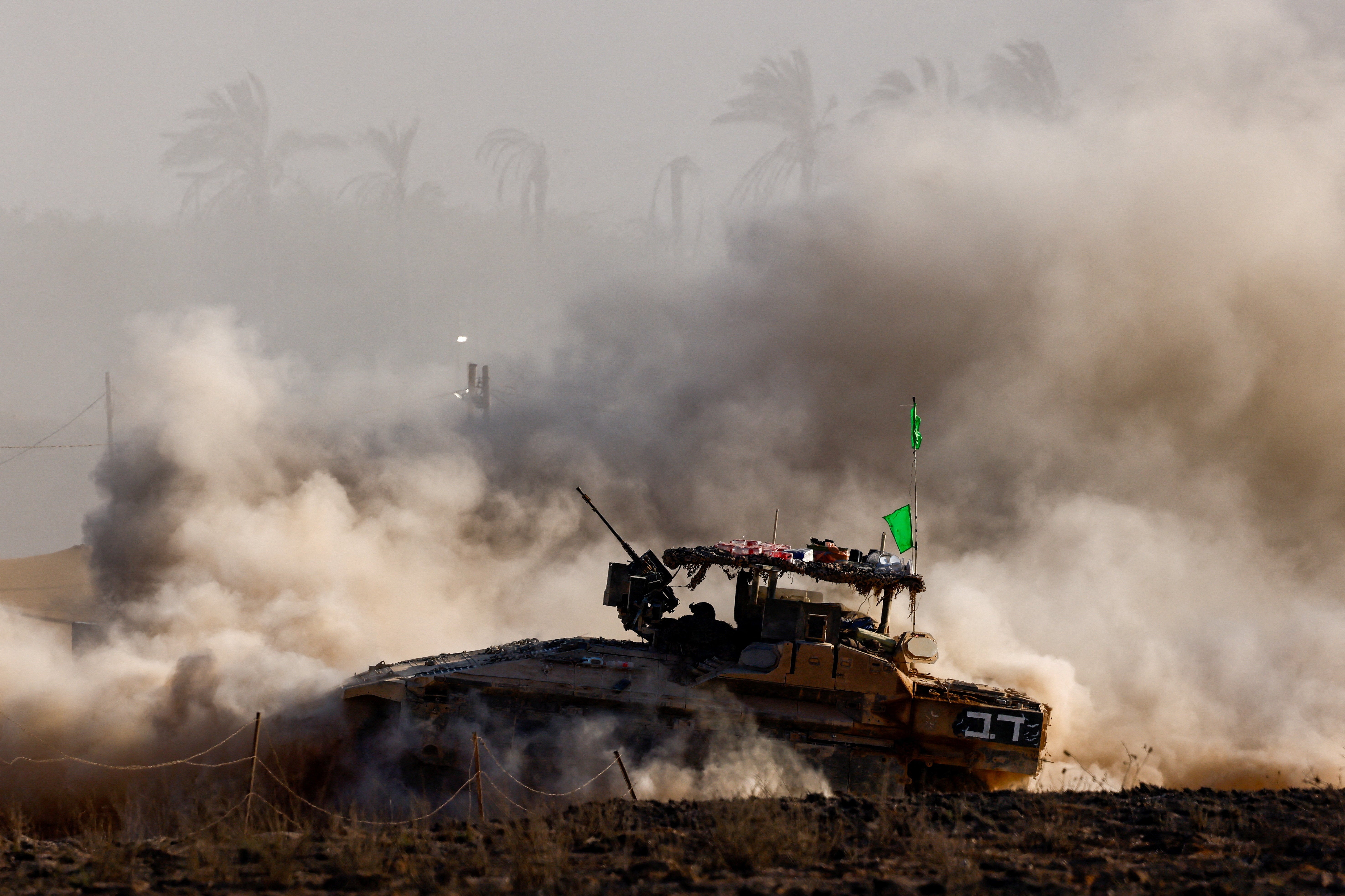 An Israeli armoured personnel carrier manoeuvres on the Israeli side of the border with Gaza. Older versions of these APCs are being used as remote-control explosive devices, according to Israeli media
