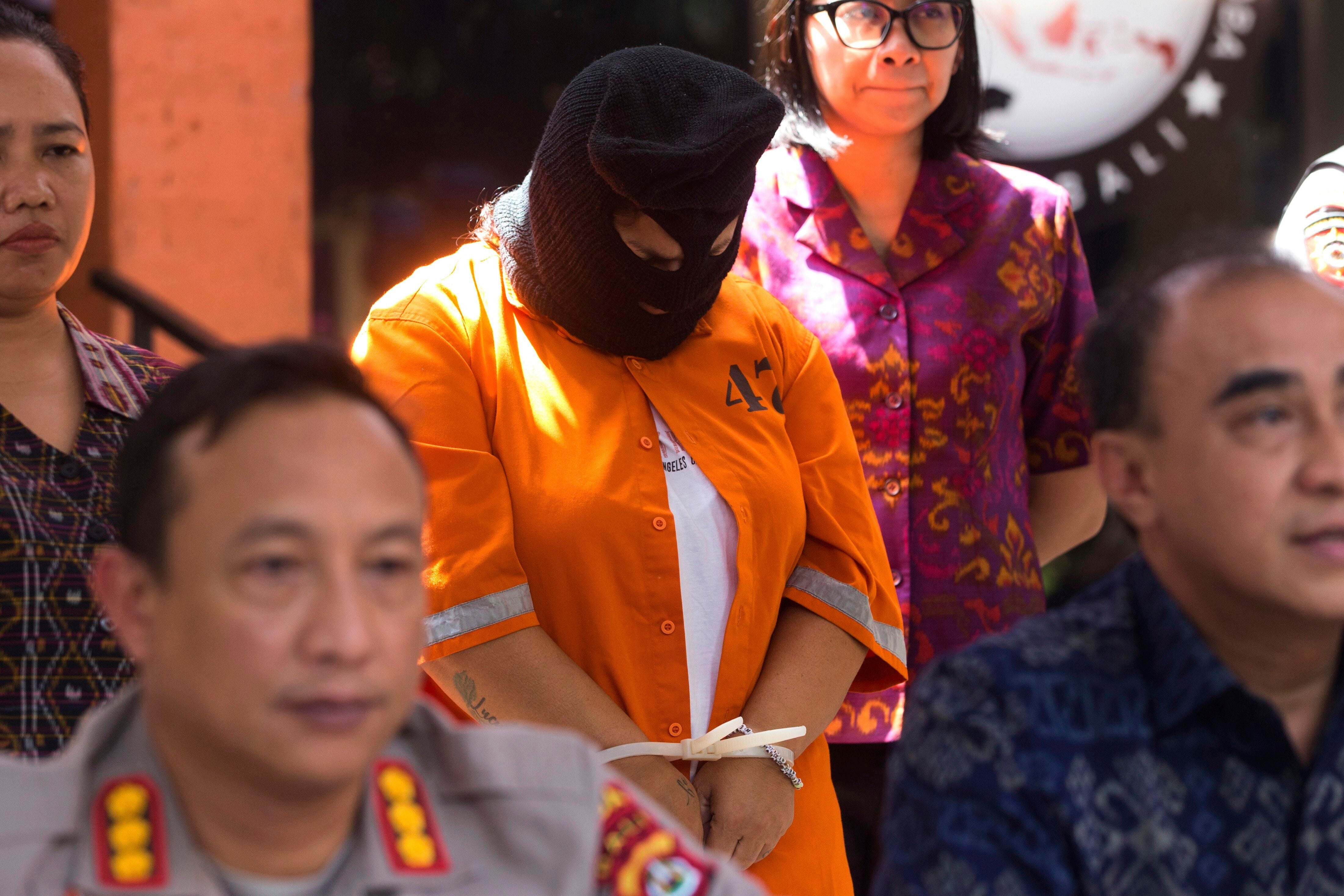 A Peruvian woman identified only as NS, center, who was arrested on accusation of smuggling cocaine into the resort island of Bali