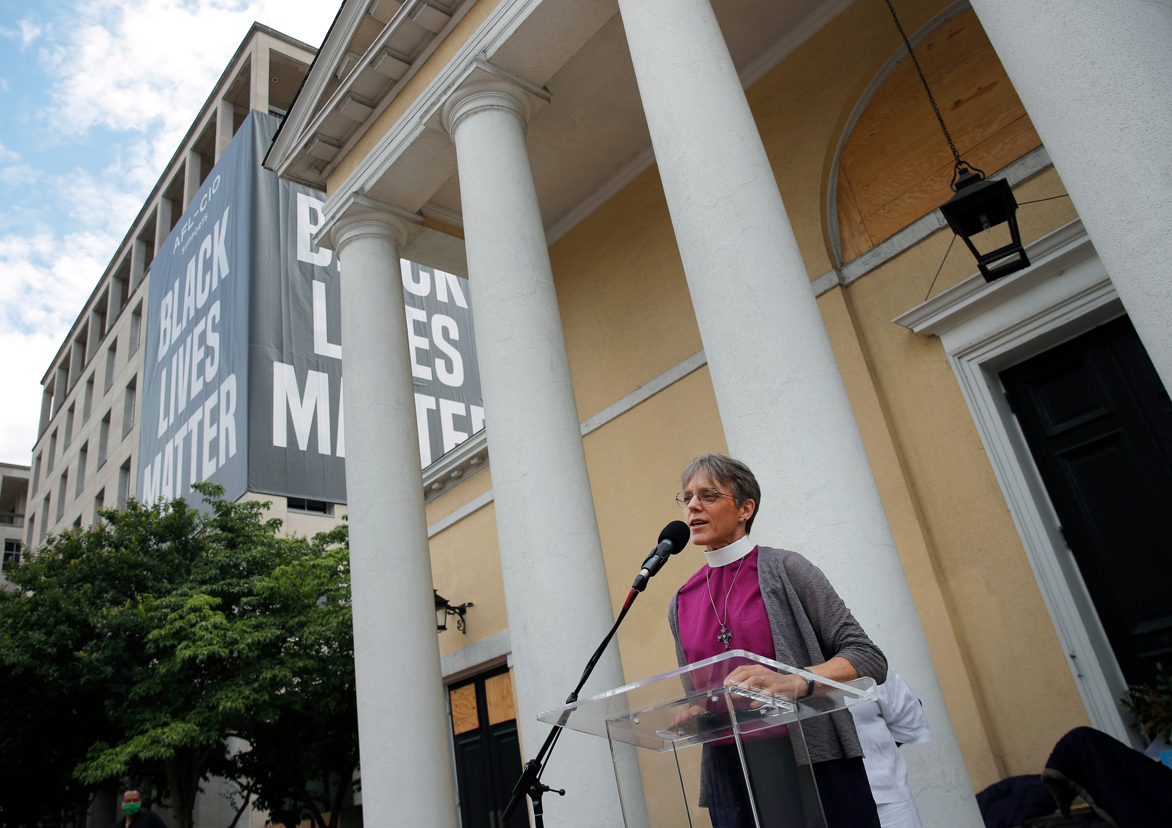 The Rev. Mariann Budde, bishop of Washington's Episcopal diocese, speaks during a service outside St. John's Episcopal Church near the White House in Washington, on June 19, 2020, with a Black Lives Matter banner in the background. (AP Photo/Carolyn Kaster, File)