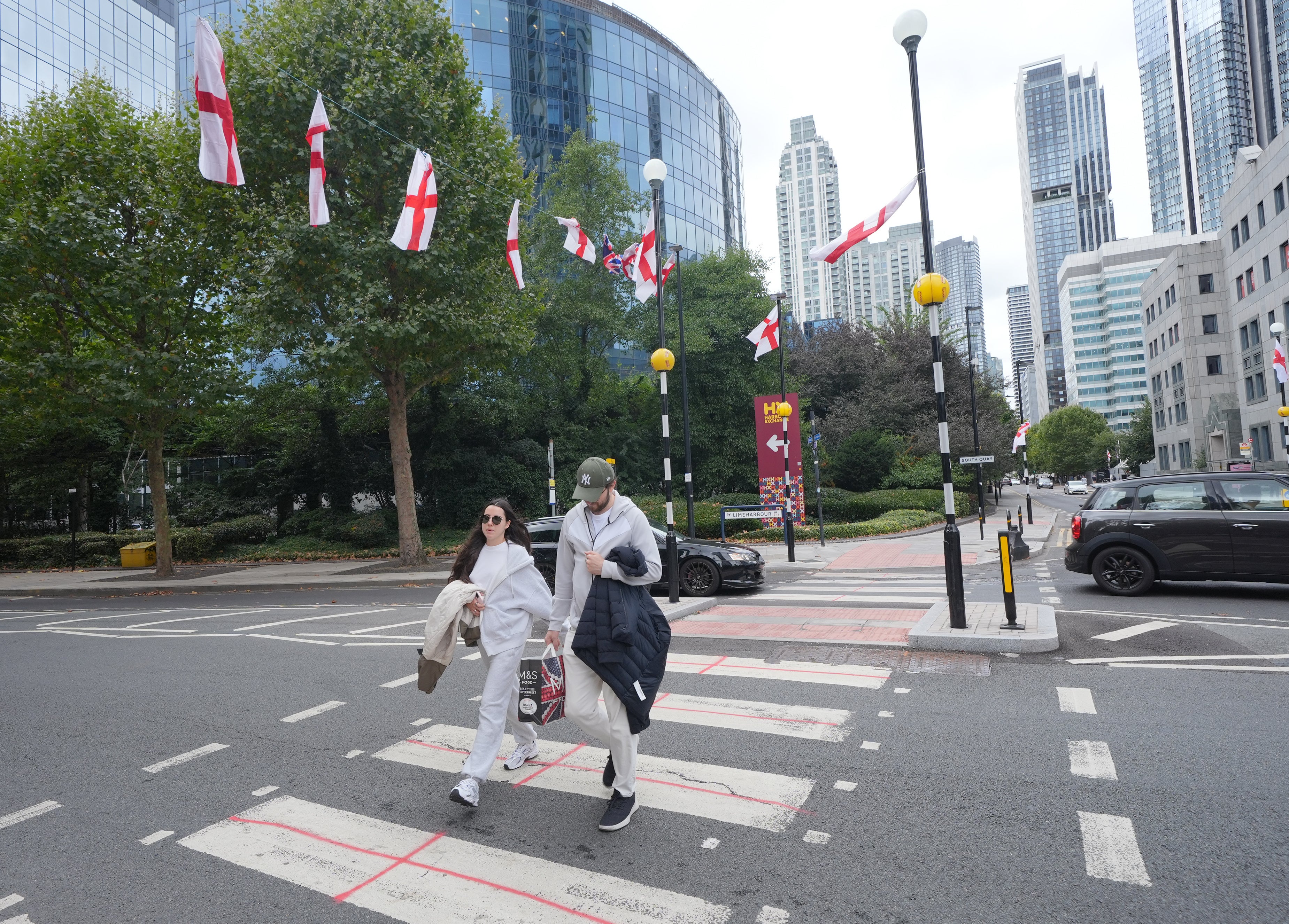 In London’s Canary Wharf, near the Britannia International Hotel where asylum seekers are planned to be housed, English flags hang over a pedestrian crossing with St George's cross graffiti on it