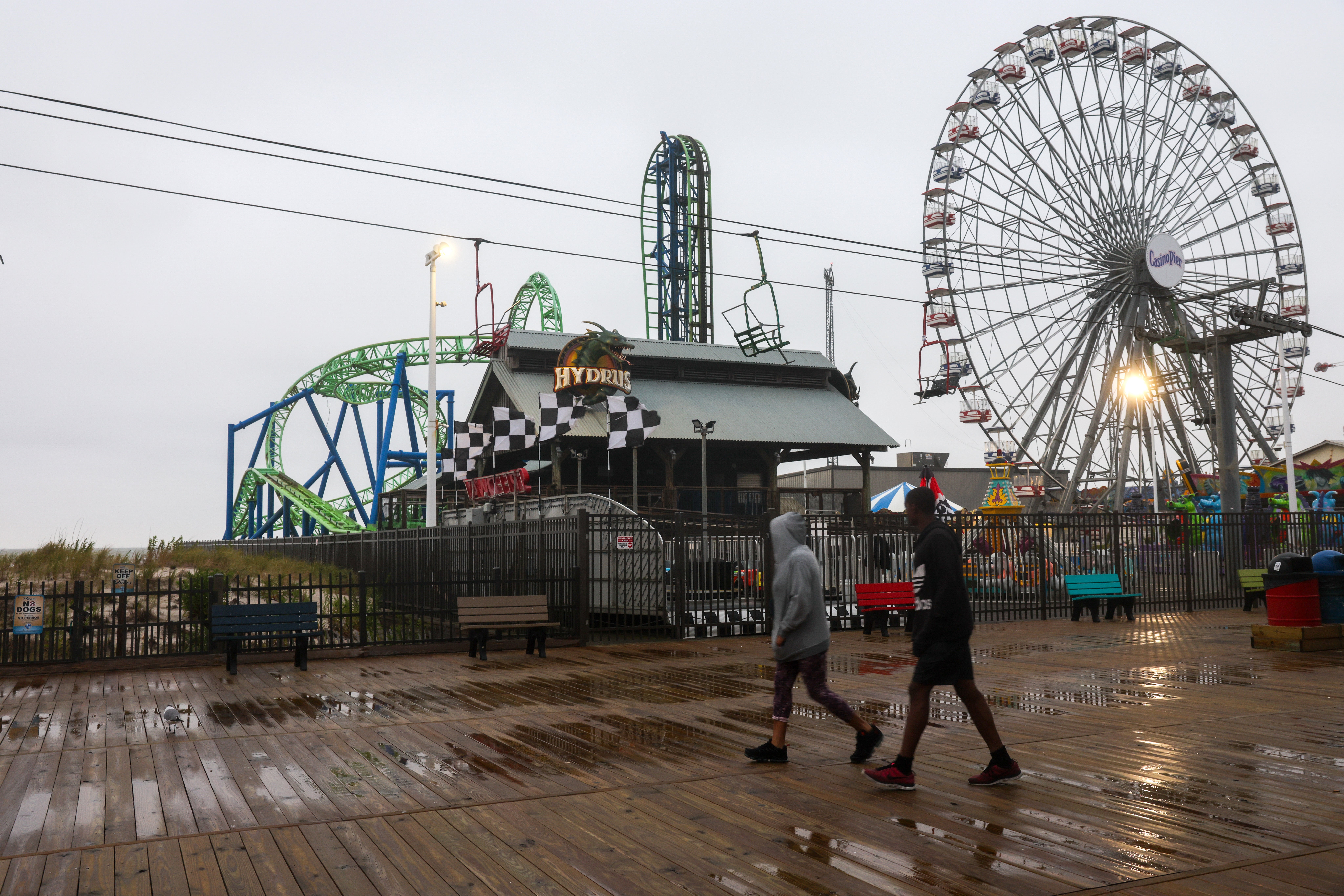 The storm continues to move north and to the east, though forecasters warn about how it will impact the mid-Atlantic and Northeast US. Pictured: People walk along the boardwalk in Seaside Heights, New Jersey.