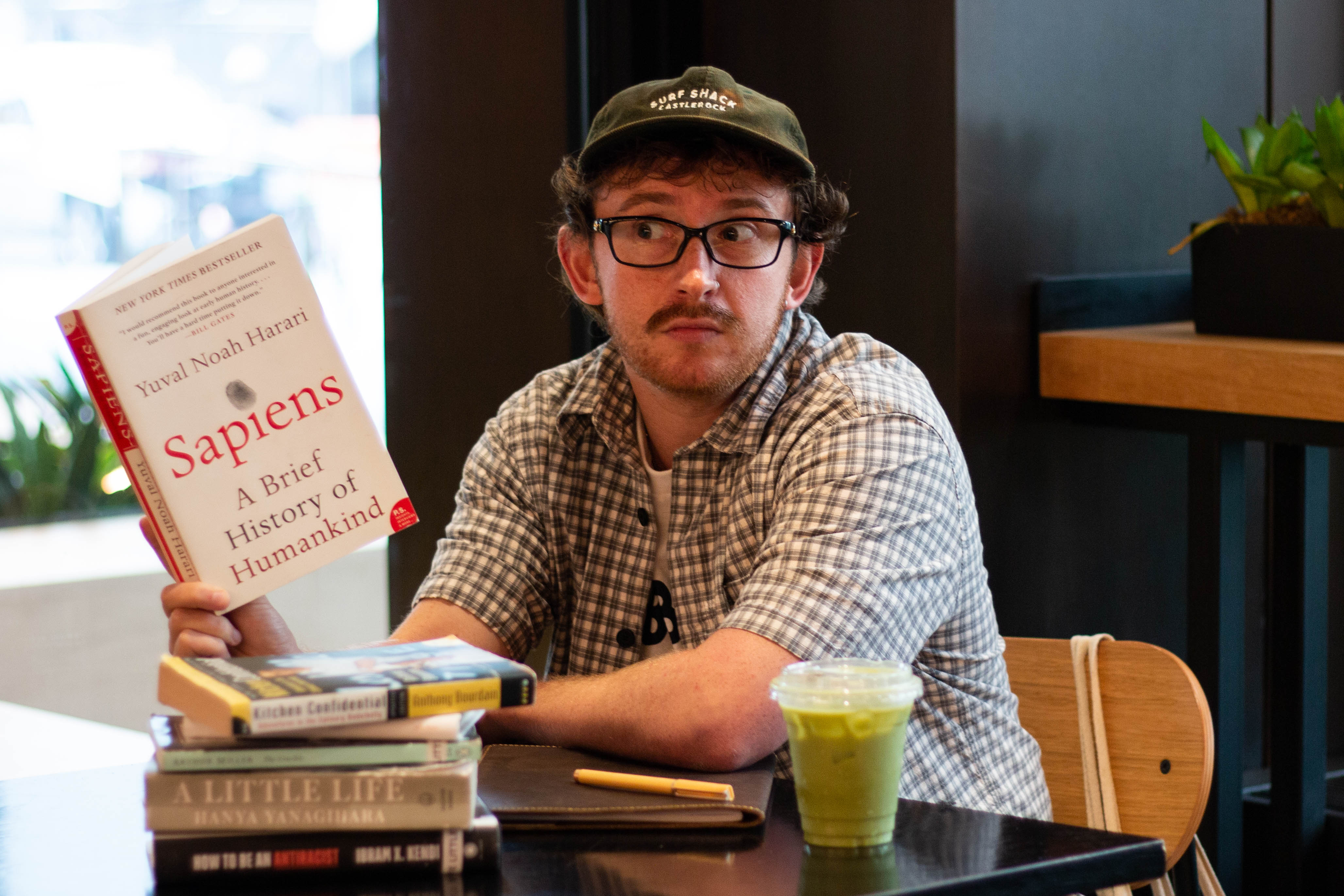 The author performing as a performative male or simply enjoying a drink and a stack of good books