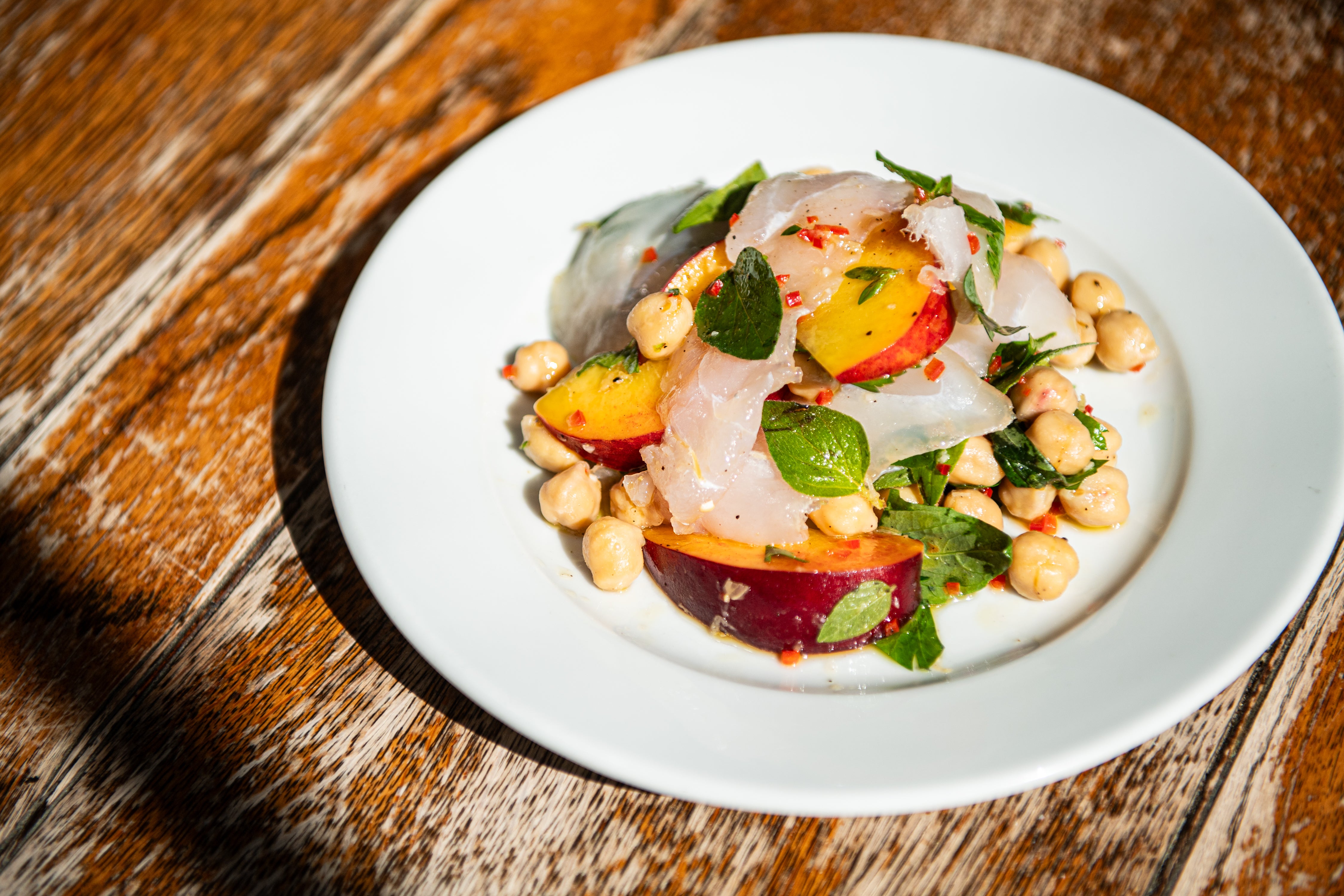A sunshine salad that’s all about contrast – soft fish, sweet fruit and a proper chilli kick