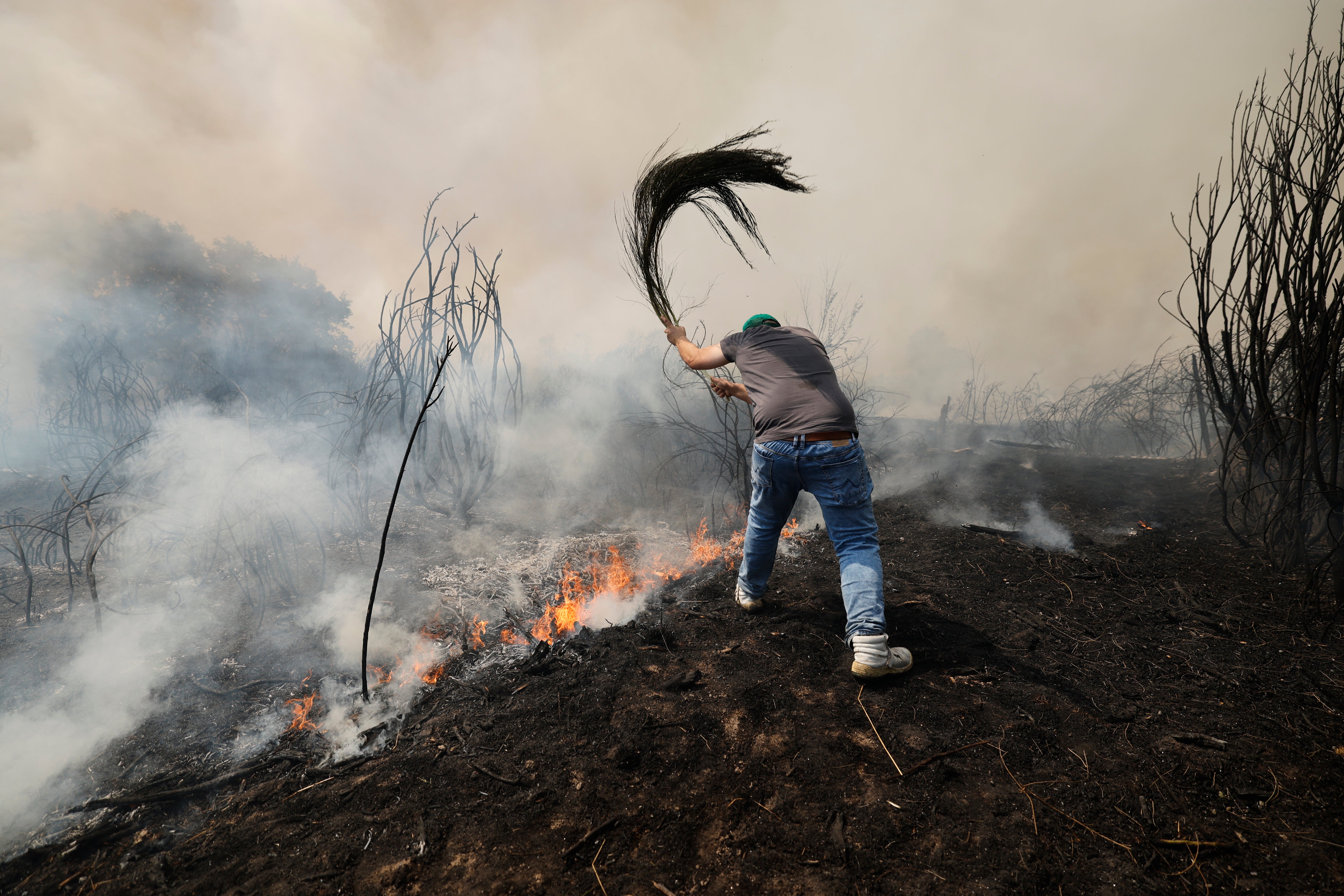 A man battles a wildfire in Veiga das Meas, northwestern Spain