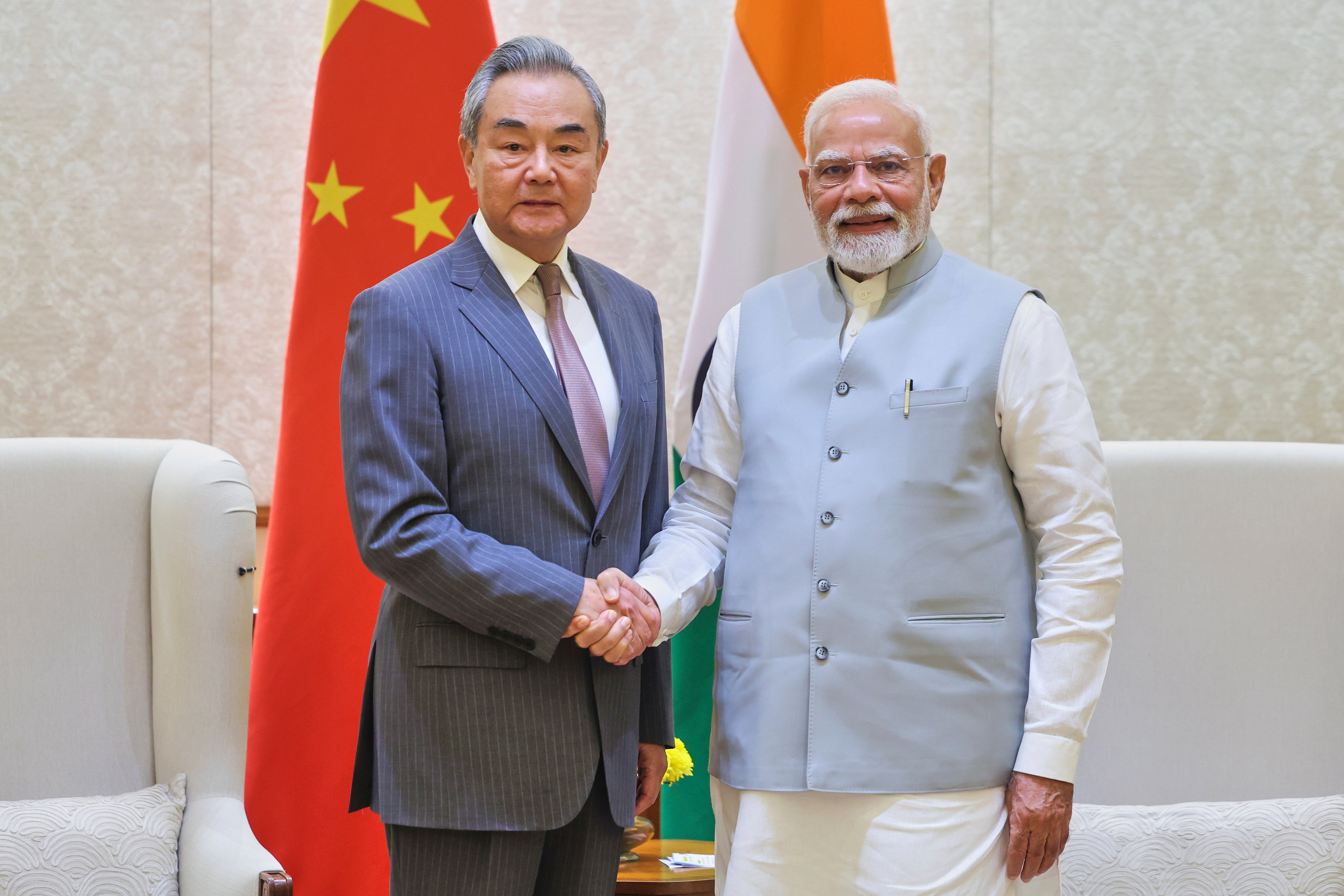 Indian Prime Minister Narendra Modi, right, shakes hand with Chinese Foreign Minister Wang Yi, left, in New Delhi, India, Tuesday