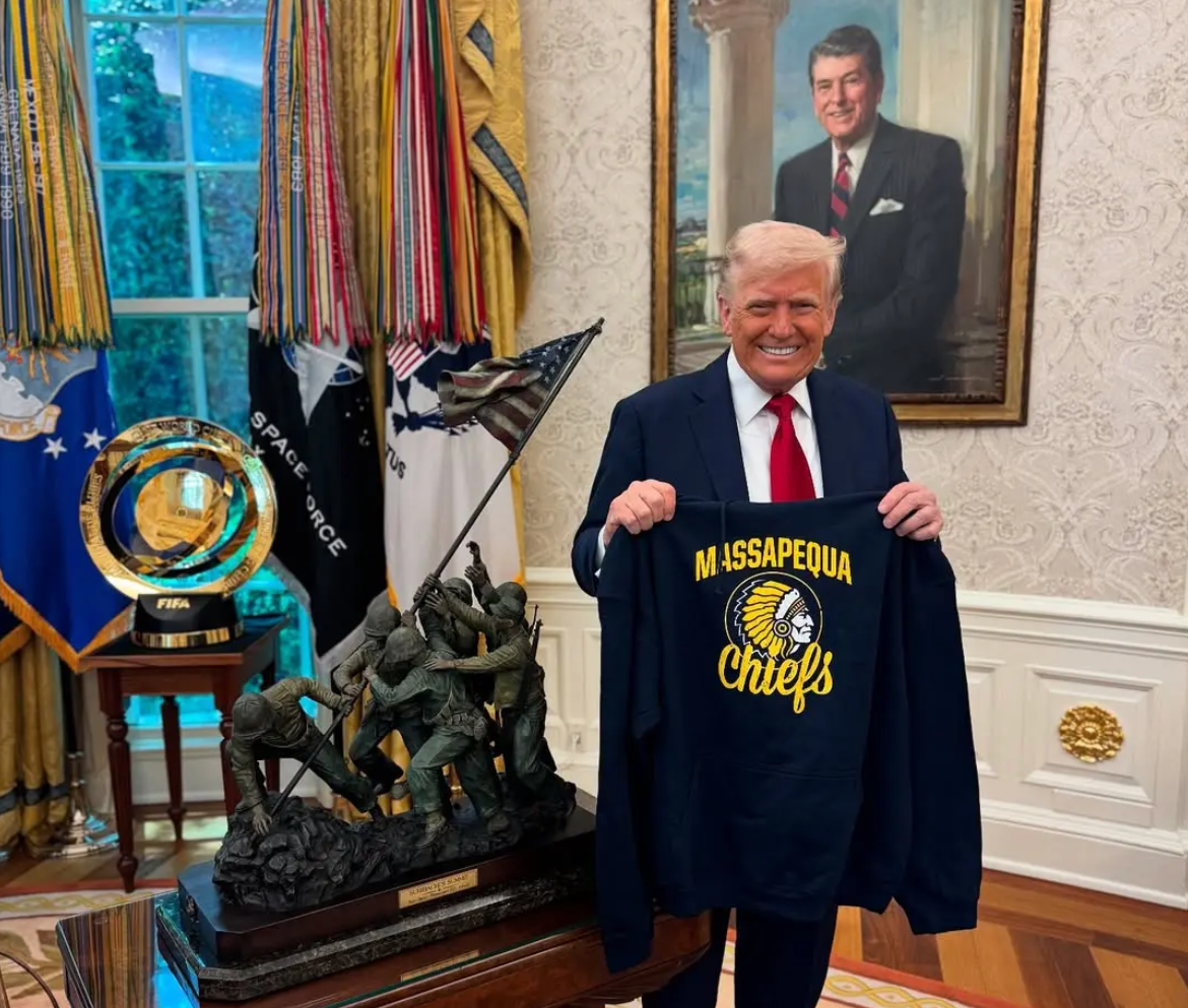 President Donald Trump poses with a Massapequa Chiefs jersey in the Oval Office of the White House in April to express his support for the school
