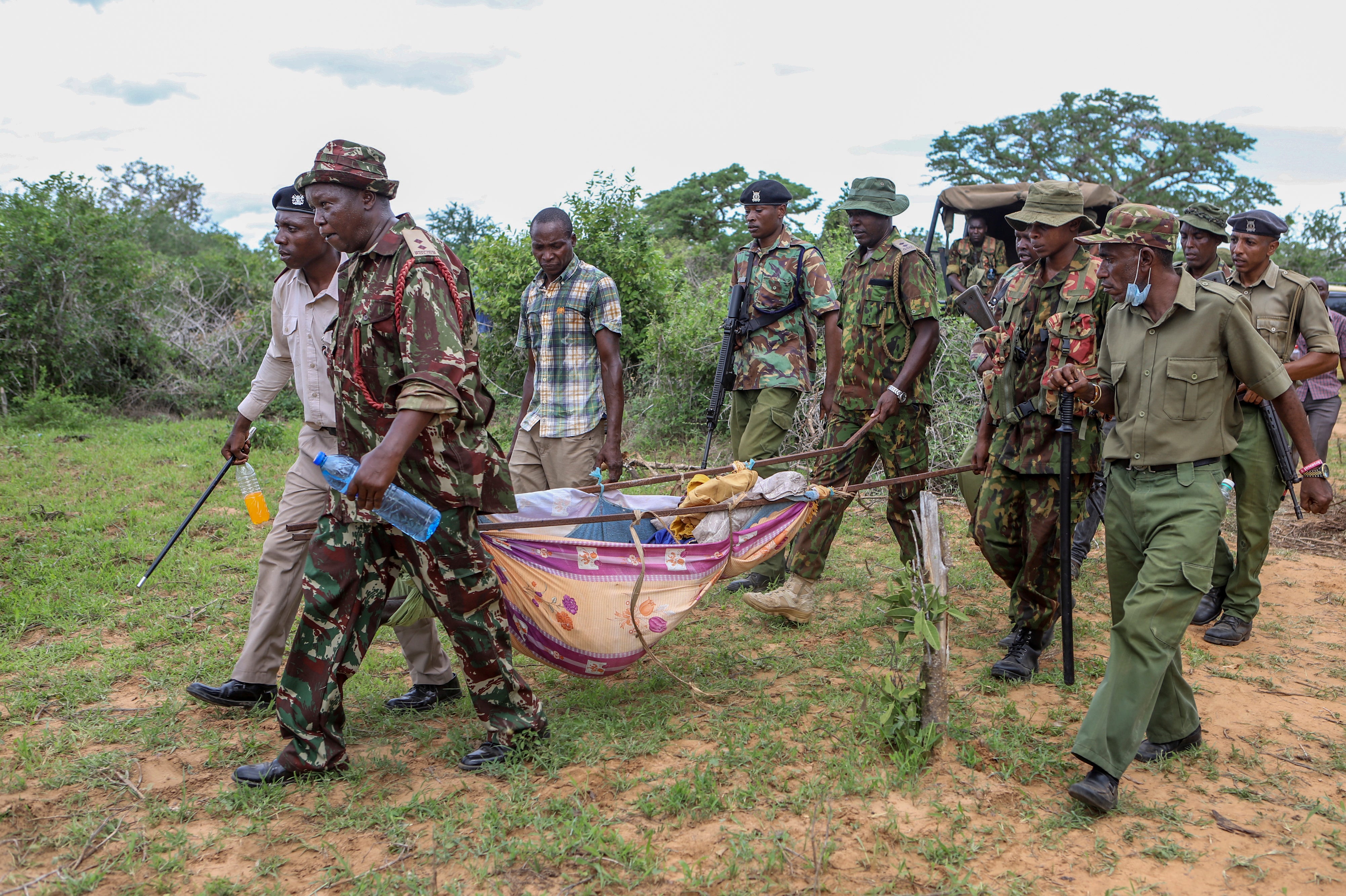 Police and local residents load the exhumed bodies of victims of a religious cult into the back of a truck in the village of Shakahola, near the coastal city of Malindi, in southern Kenya, Sunday, April 23, 2023. (AP Photo/File)