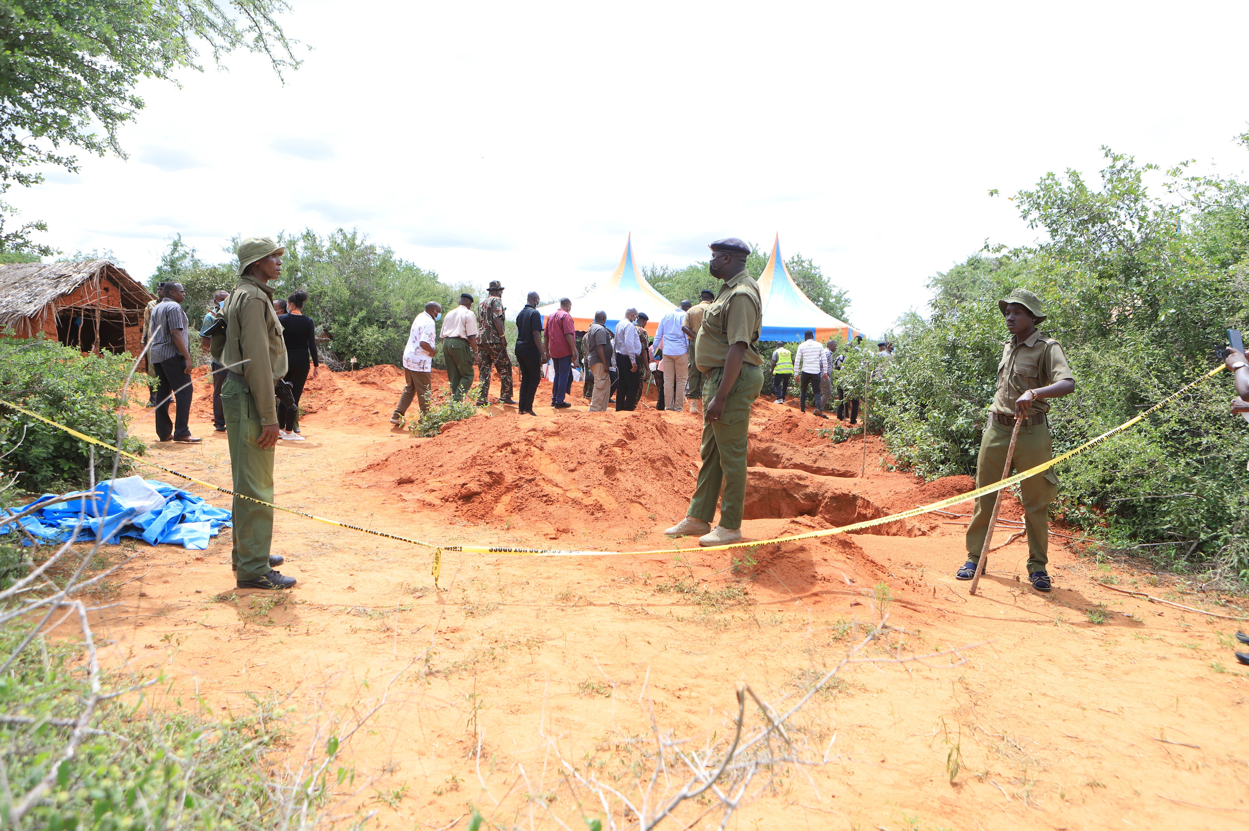 Police officers stand near a cordon at the scene where bodies of victims of a Christian cult are being exhumed in a forest in the Shakahola area, near Malindi town, Kenya, Tuesday, April 25, 2023. (AP Photo/File)