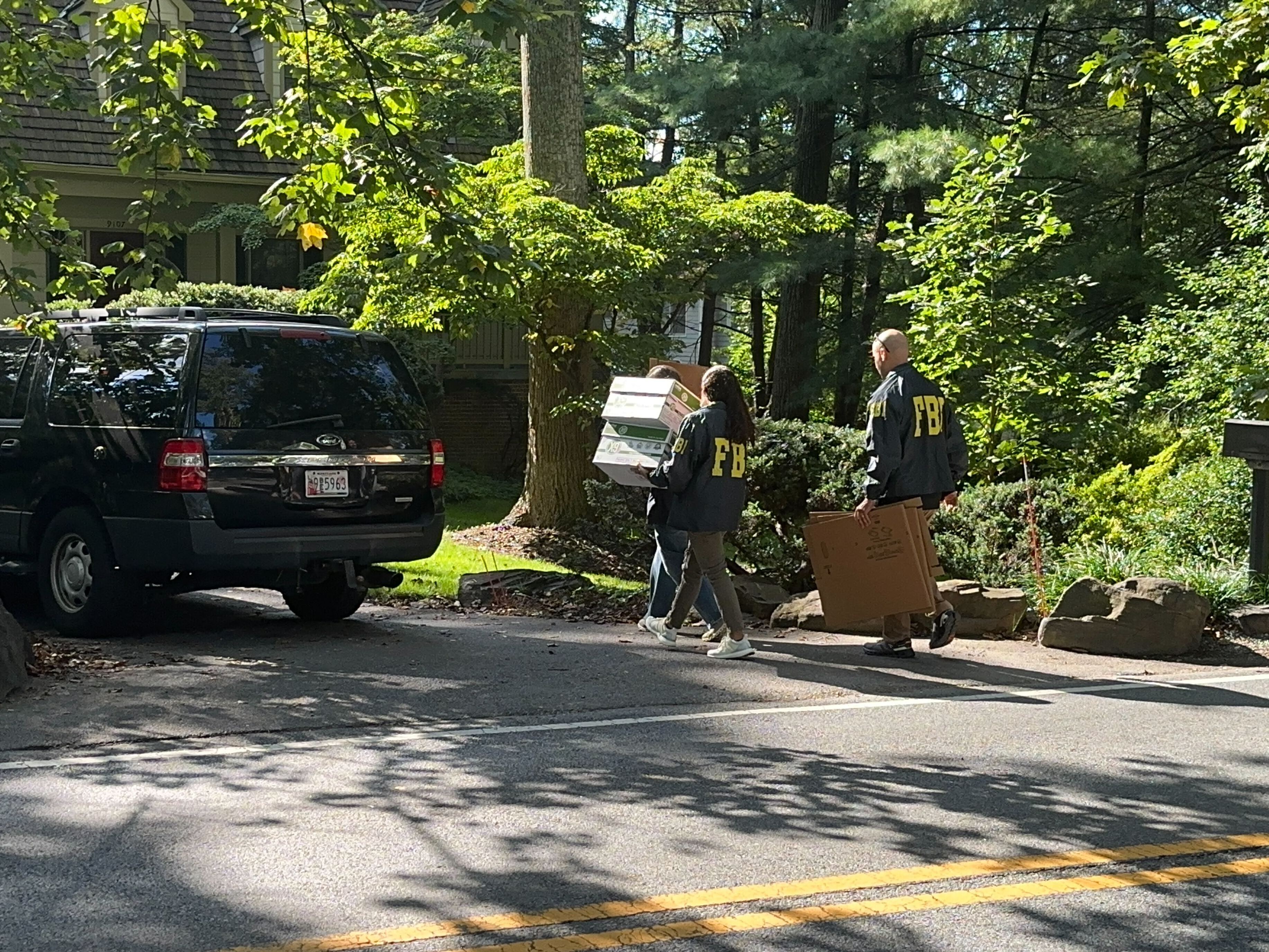 FBI agents are seen outside the home of former national security adviser John Bolton.