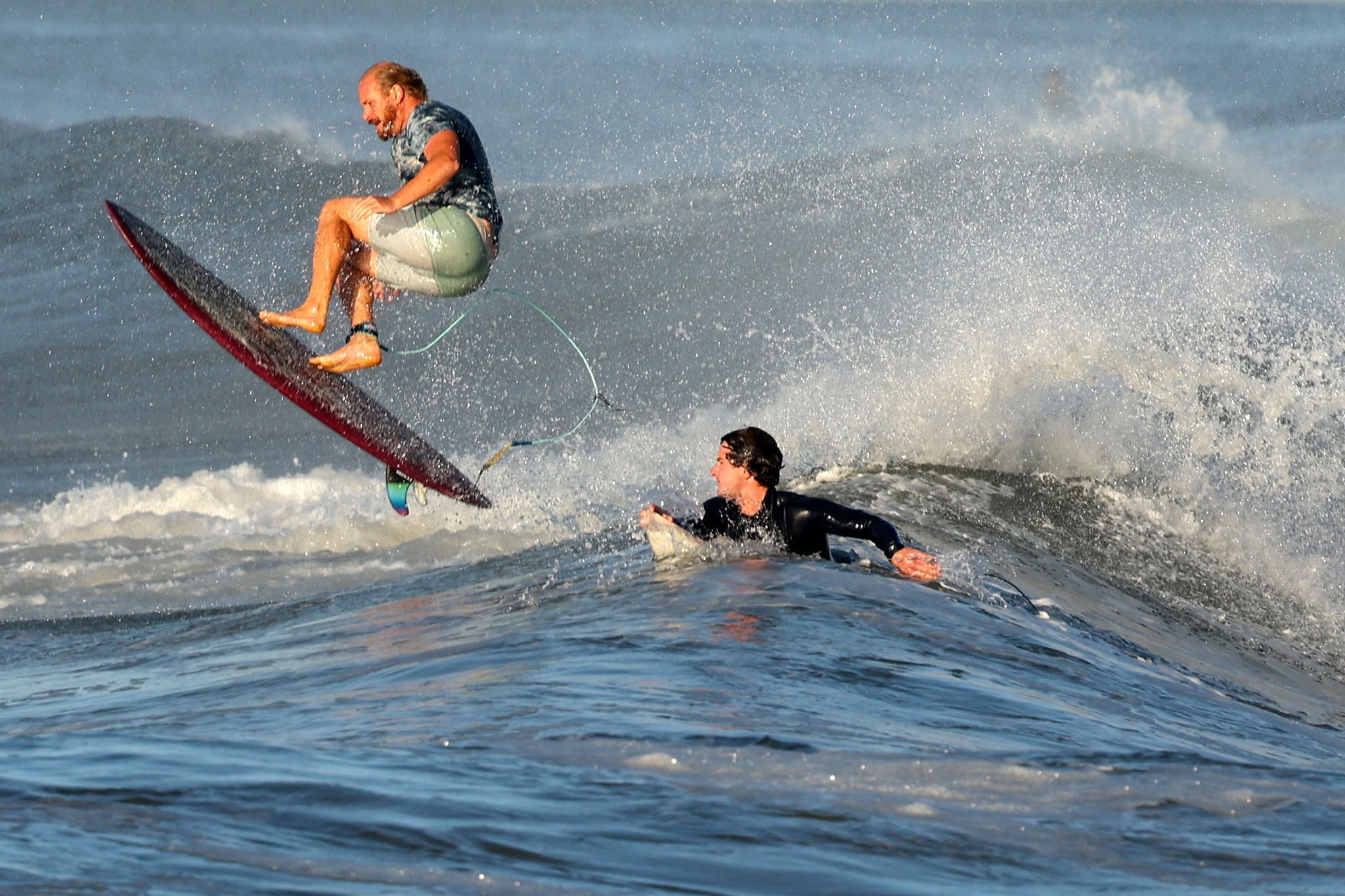 Surfers ride the waves amid Hurricane Erin, the first hurricane of the 2025 Atlantic season, in the Atlantic Ocean at Lido Beach, New York