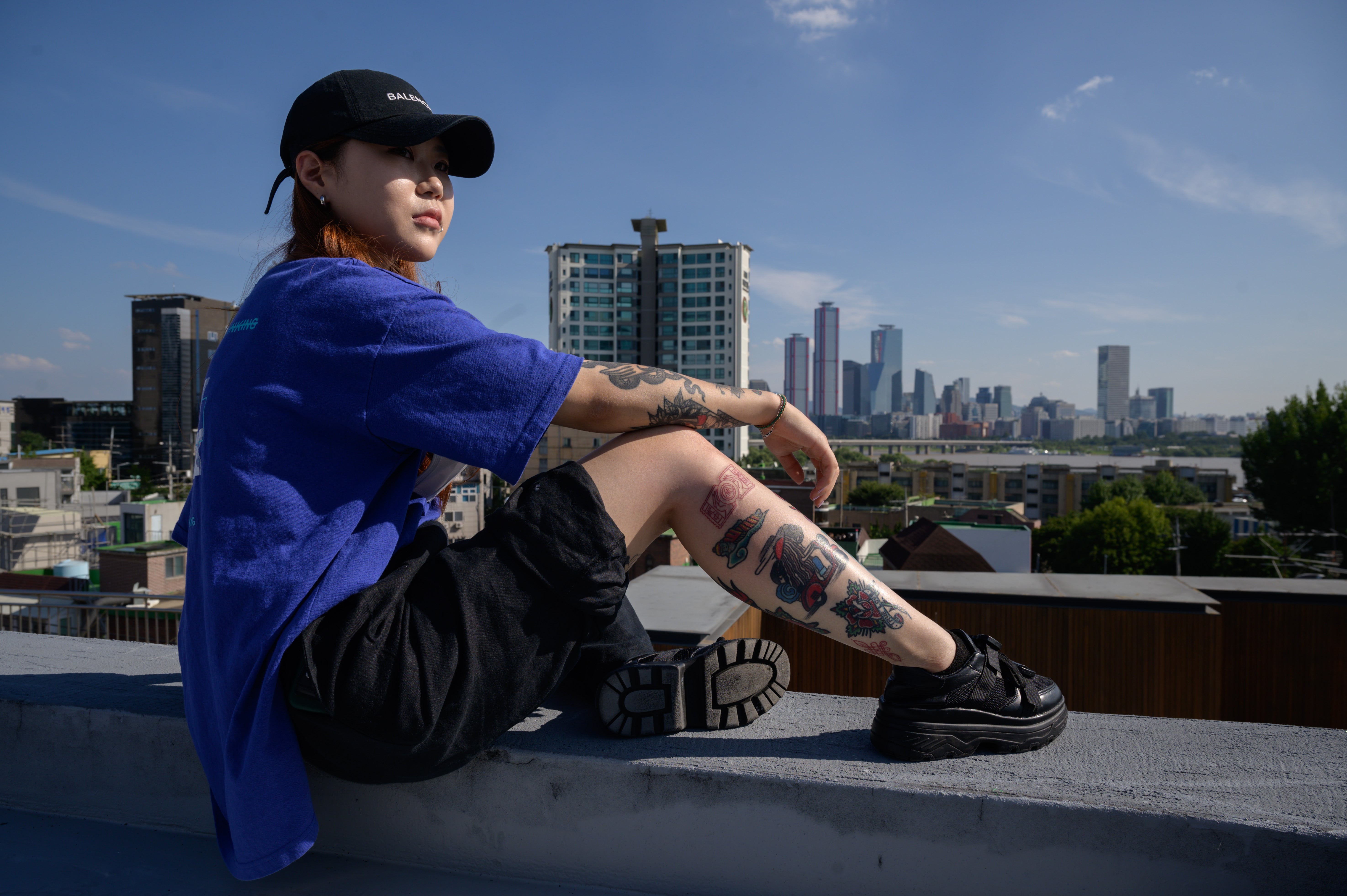In a photo taken on 4 September 2020, tattoo artist Seo Uri poses for a photo before the city skyline of Seoul. - In South Korea, while tattooing itself is not illegal, it is classed as a medical procedure and may only be carried out by a fully qualified doctor, with up to two years in prison for violators.