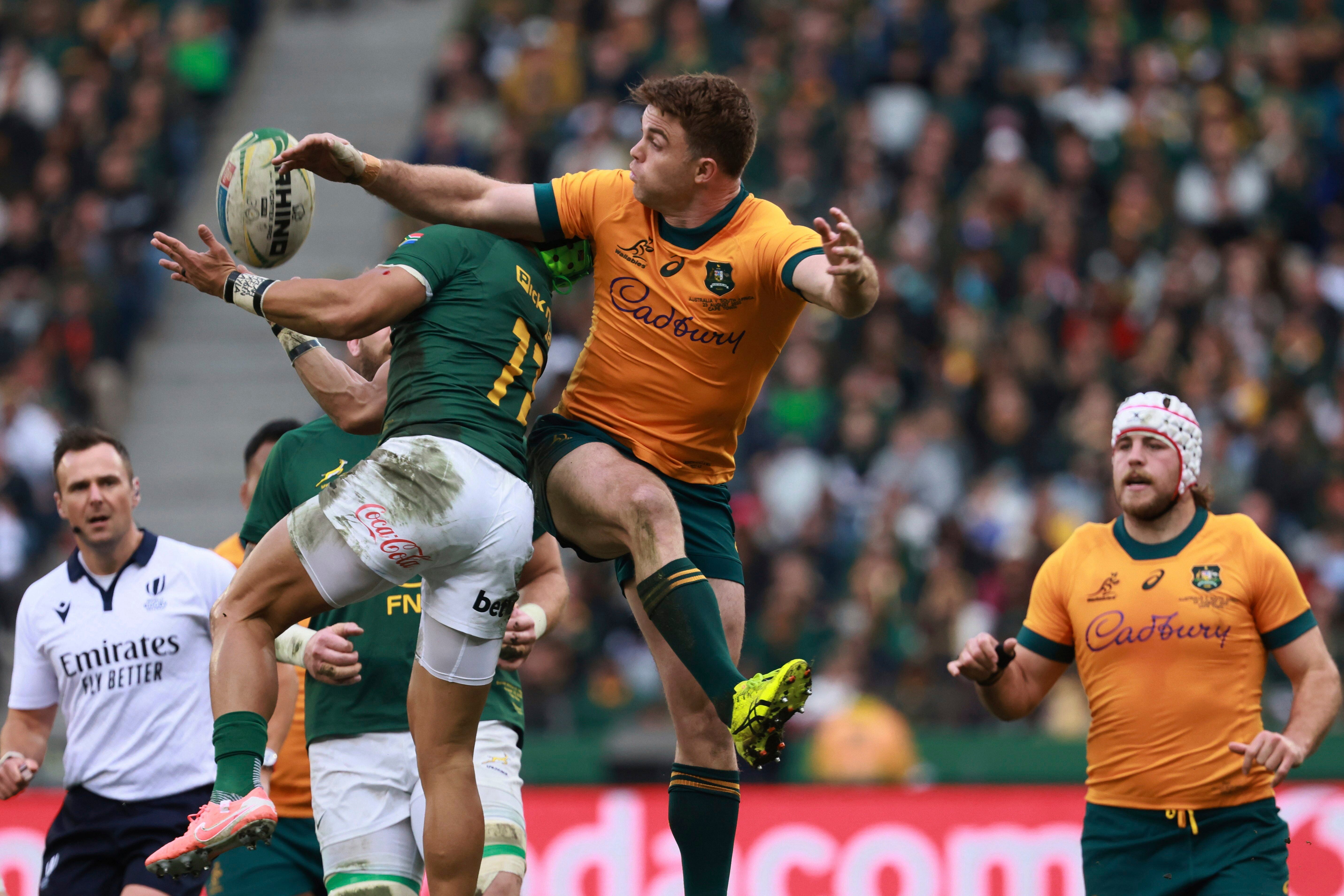 Australia's Billy Pollard, centre, jumps as and looses the ball to South Africa's Cheslin Kolbe