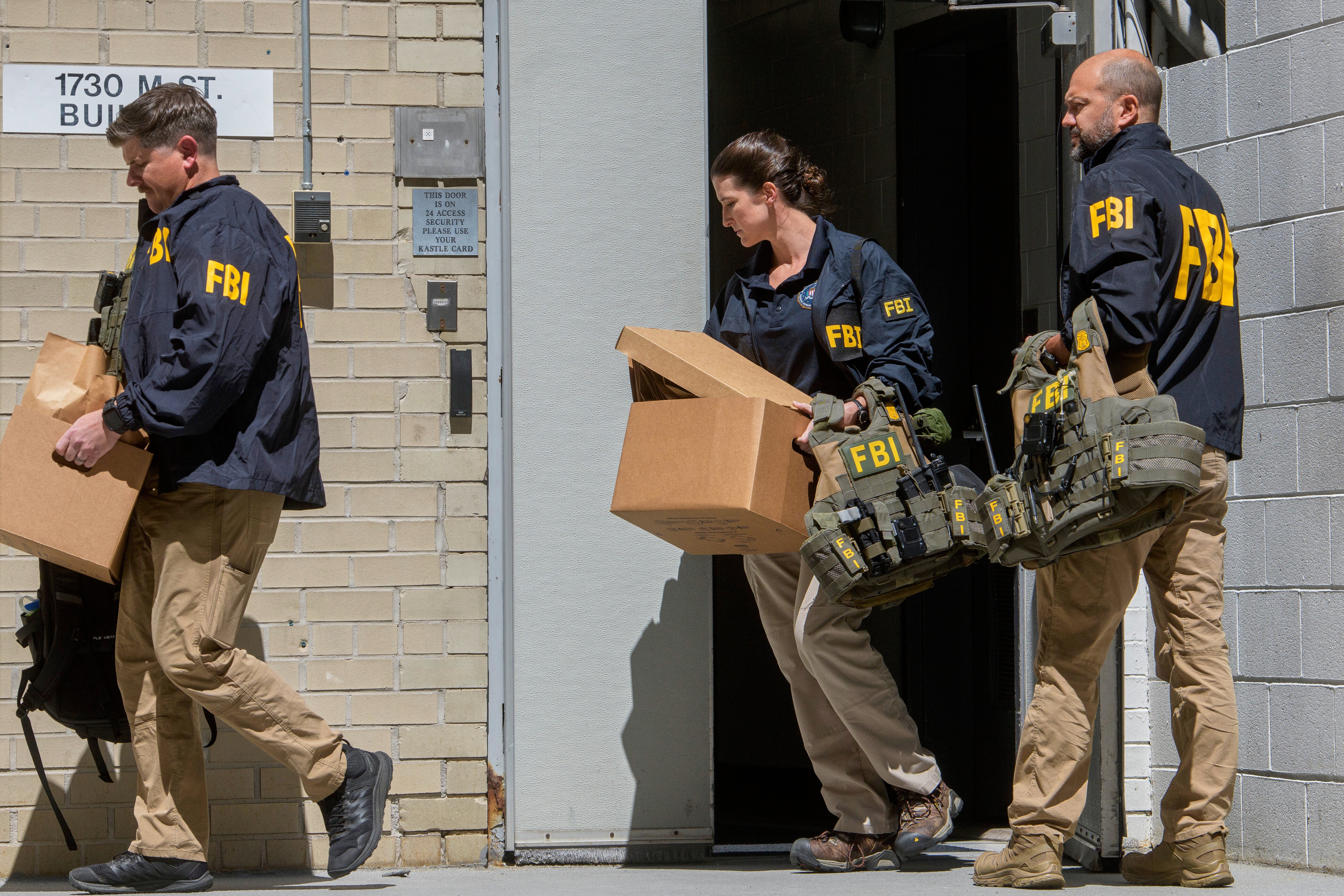 FBI agents carry boxes from Bolton’s office in Washington, D.C., less than two weeks after Bolton suggested Trump was running a ‘retribution presidency’