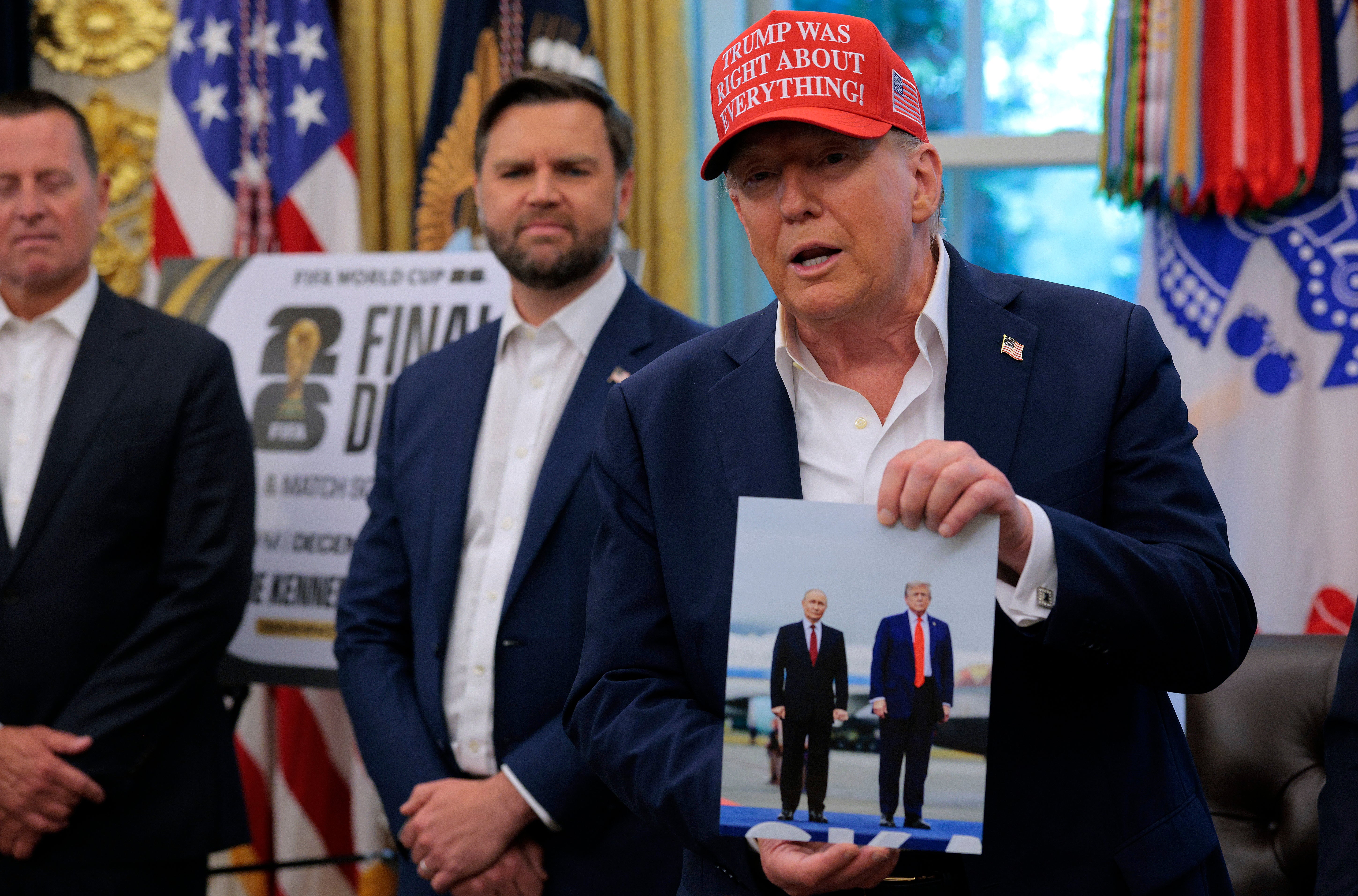 US president Donald Trump holds a photograph he said was given to him as a gift by Russian president Vladimir Putin in the Oval Office