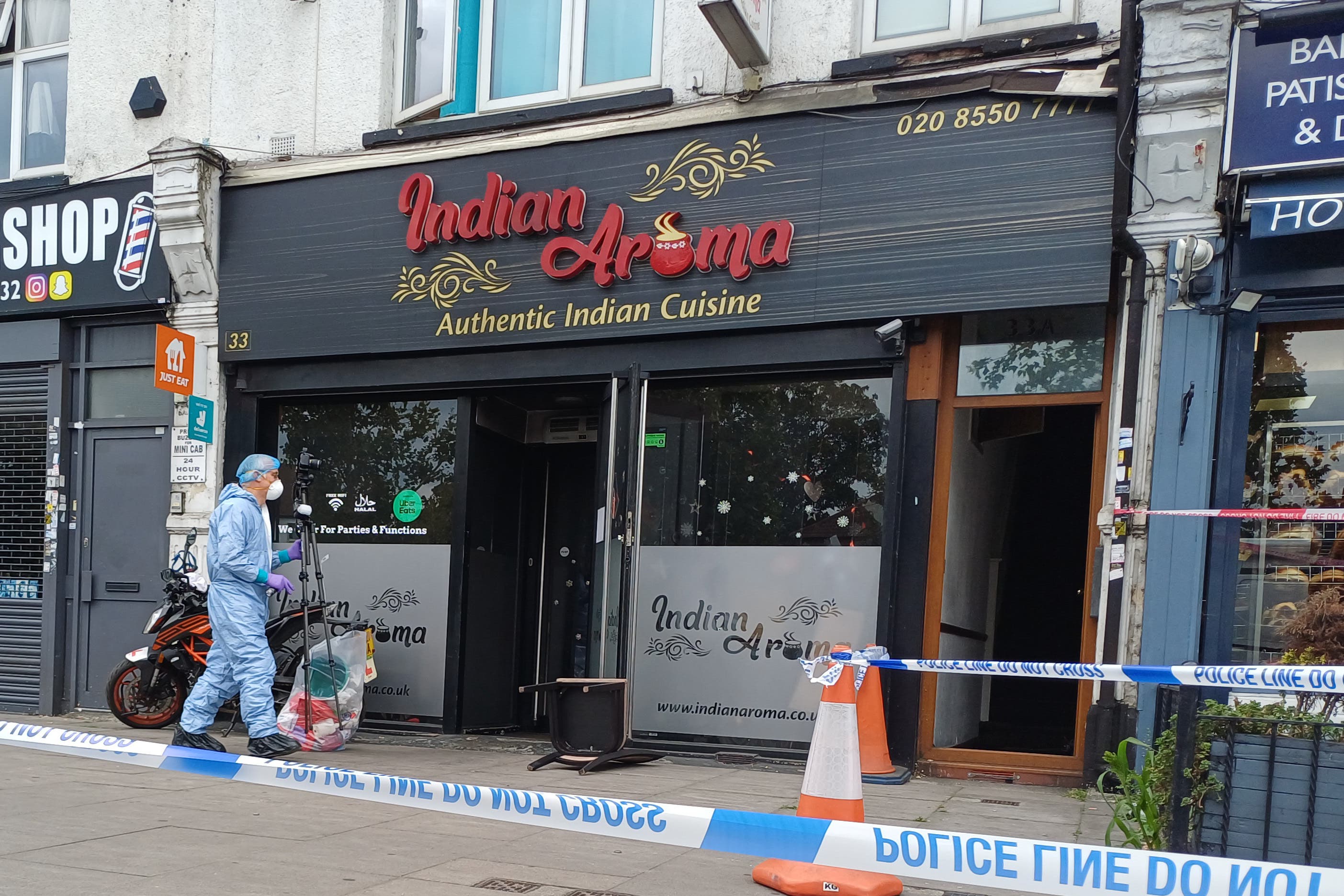 A forensic investigator at a restaurant in Ilford, east London (Helen William/PA)