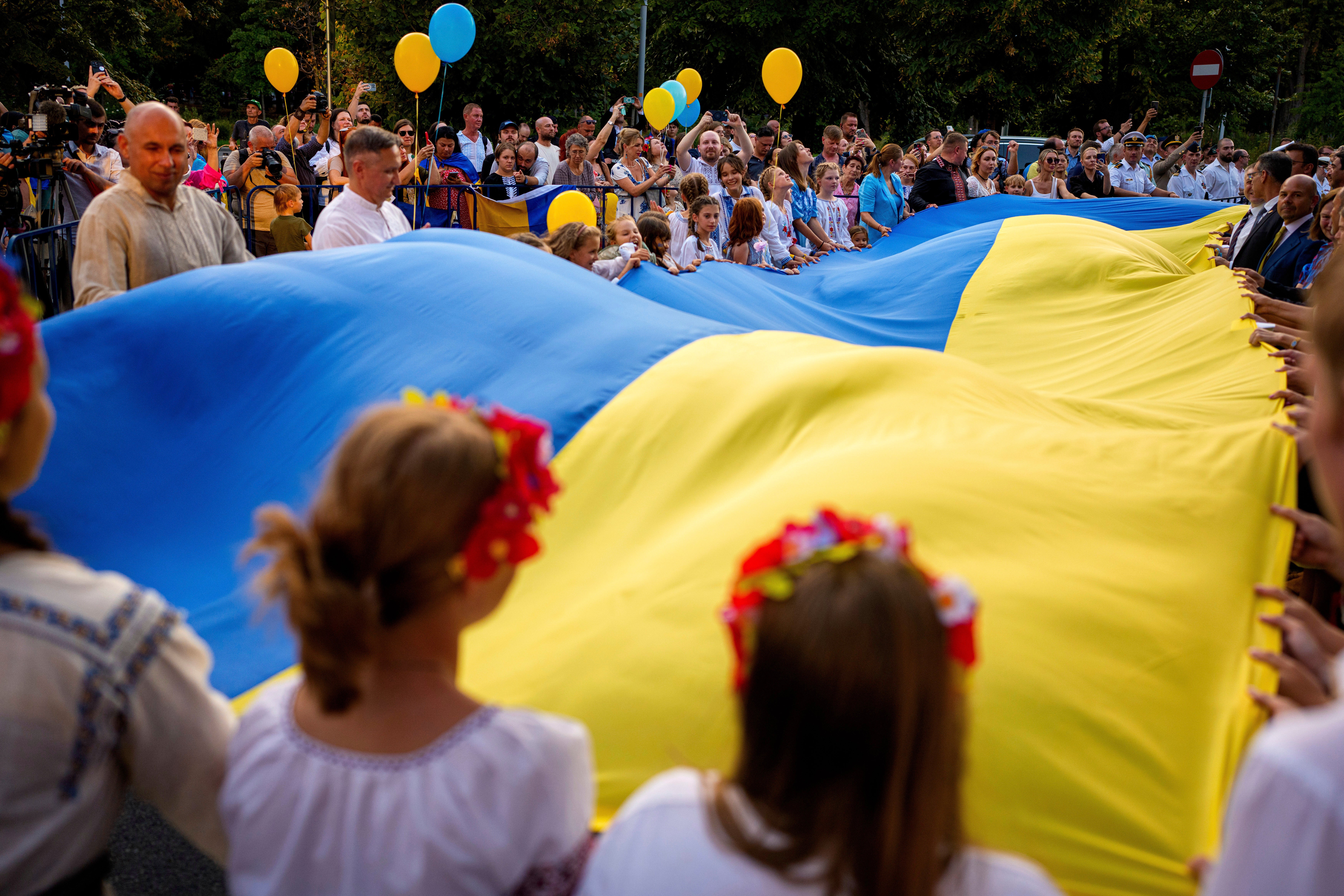 Participants in Bucharest wave a Ukrainian flag during an event of solidarity with Ukraine, marking its Independence Day on Sunday
