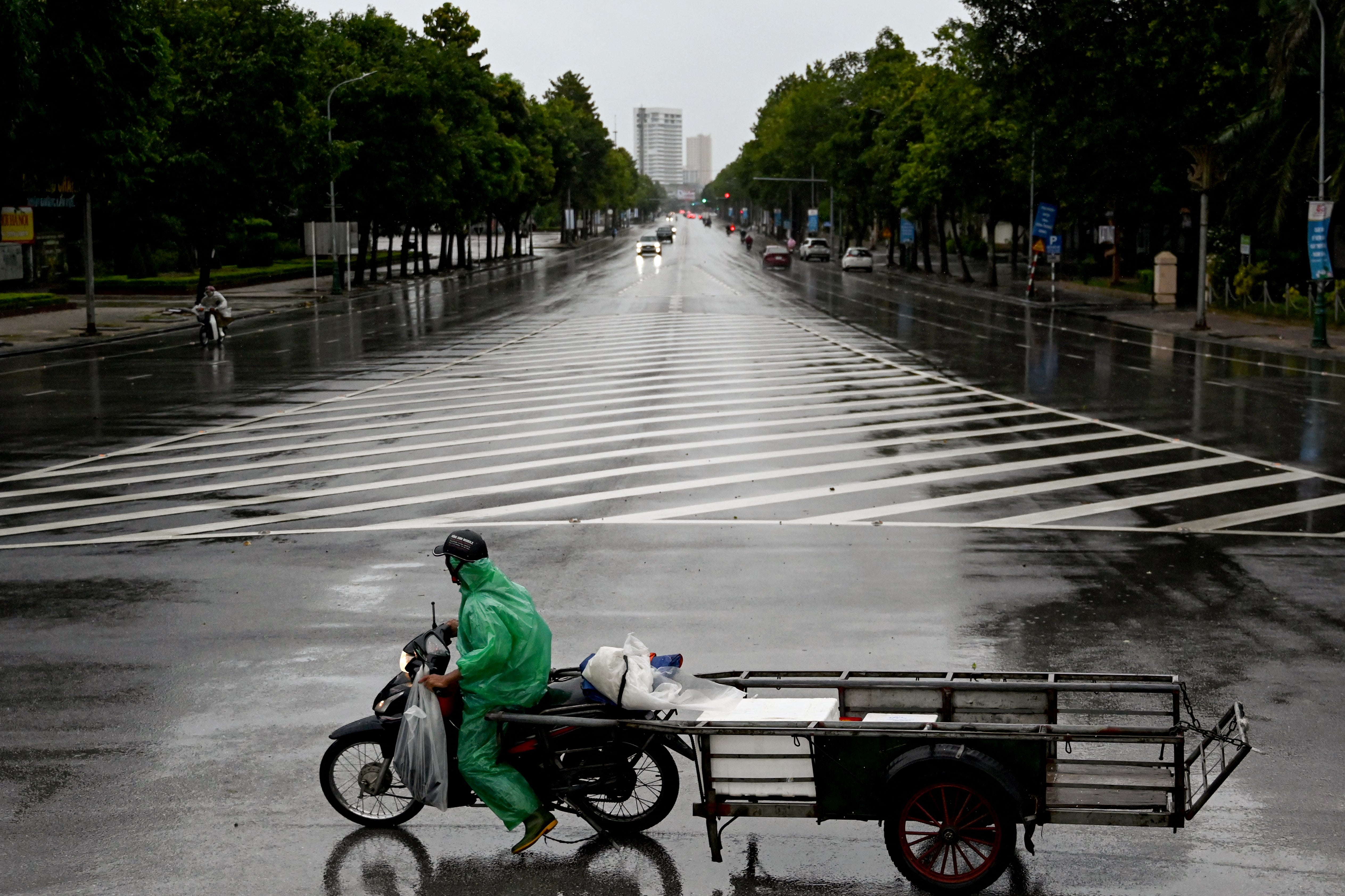 A man rides a motorbike on a road before Typhoon Kajiki makes landfall in Vietnam, in Nghe An province on 25 August 2025