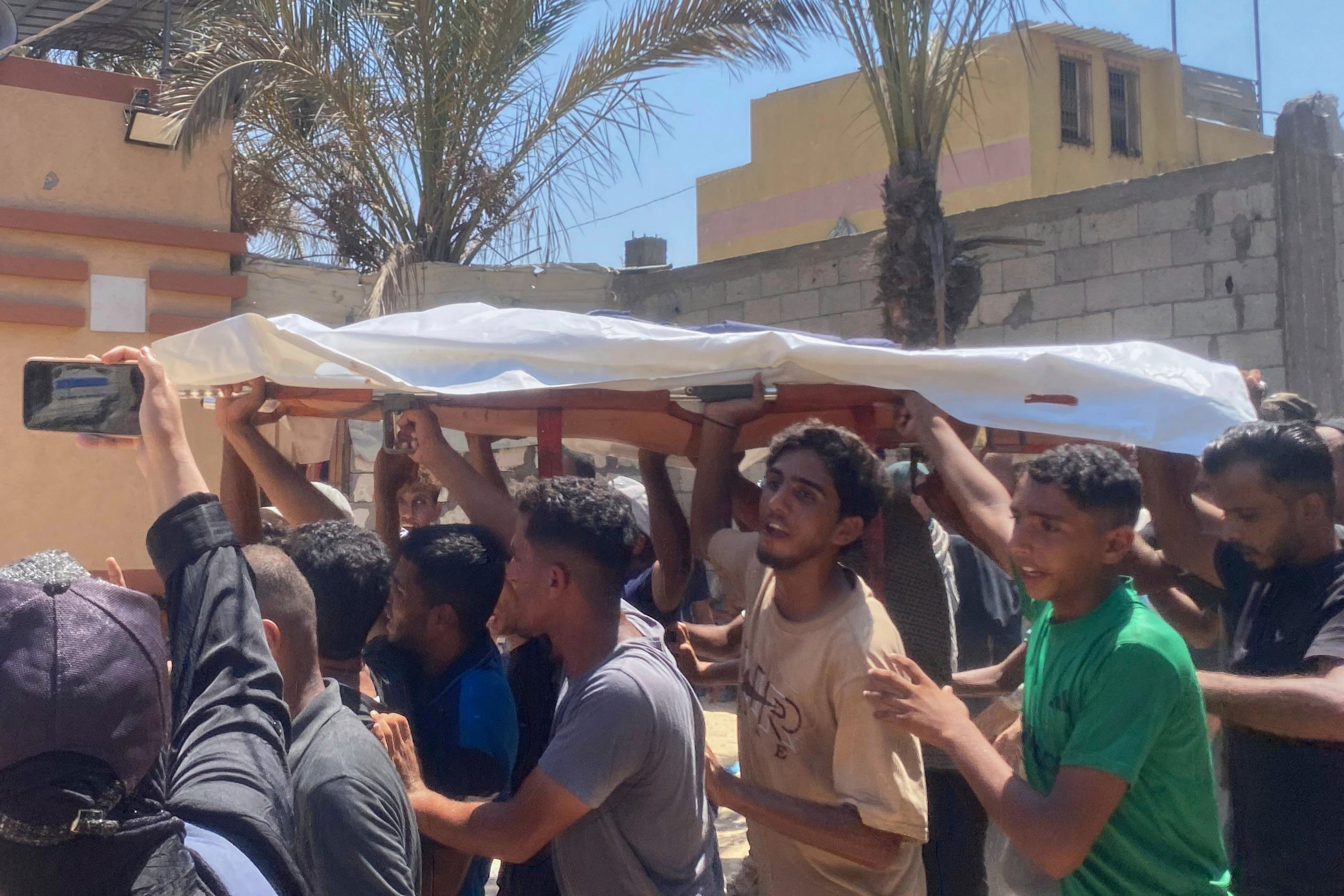 The body of freelance journalist Maryam Abu Daqqa is carried for burial after she was killed in an Israeli strike