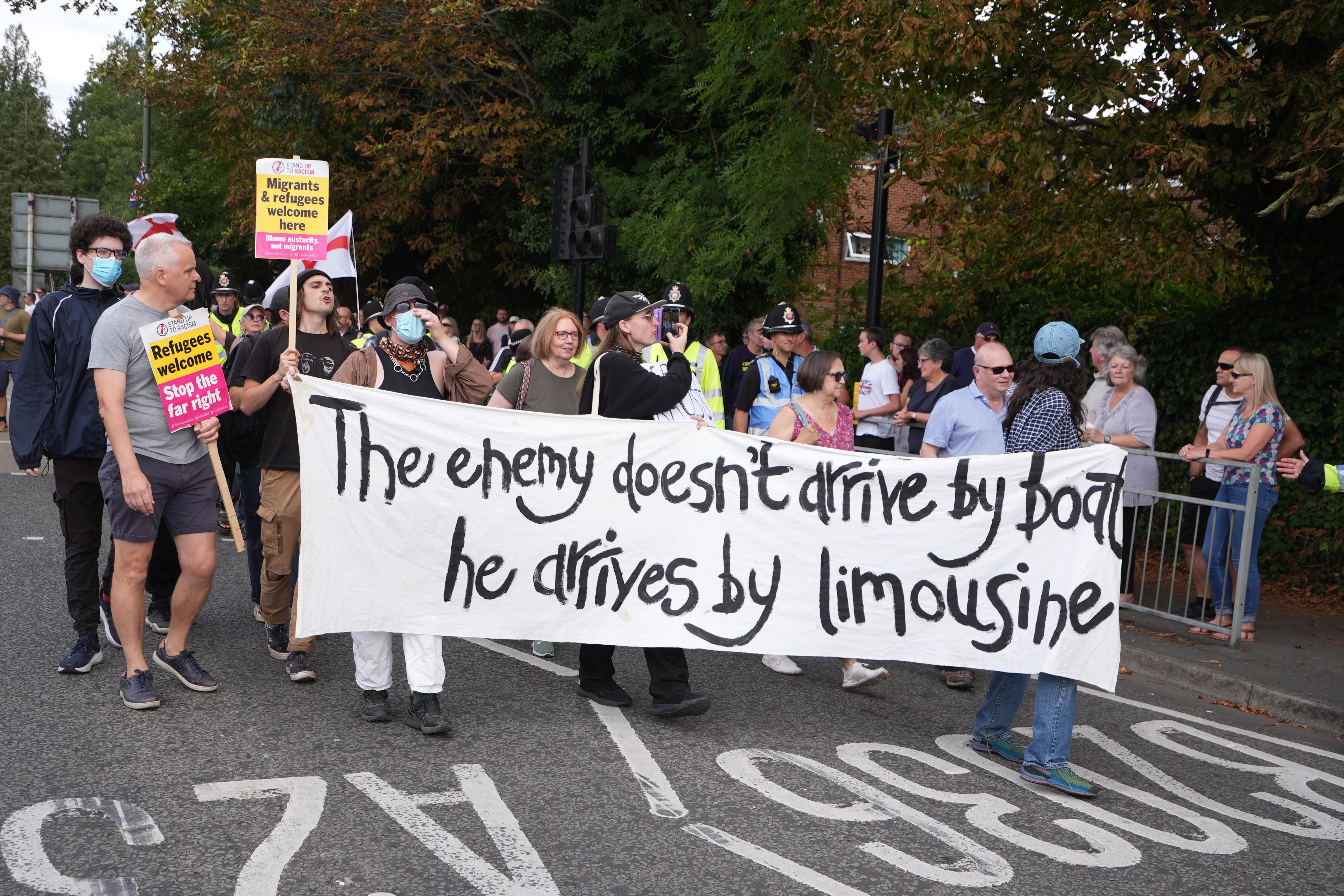 People take part in a Stand Up To Racism rally outside a hotel in Horley, Surrey.