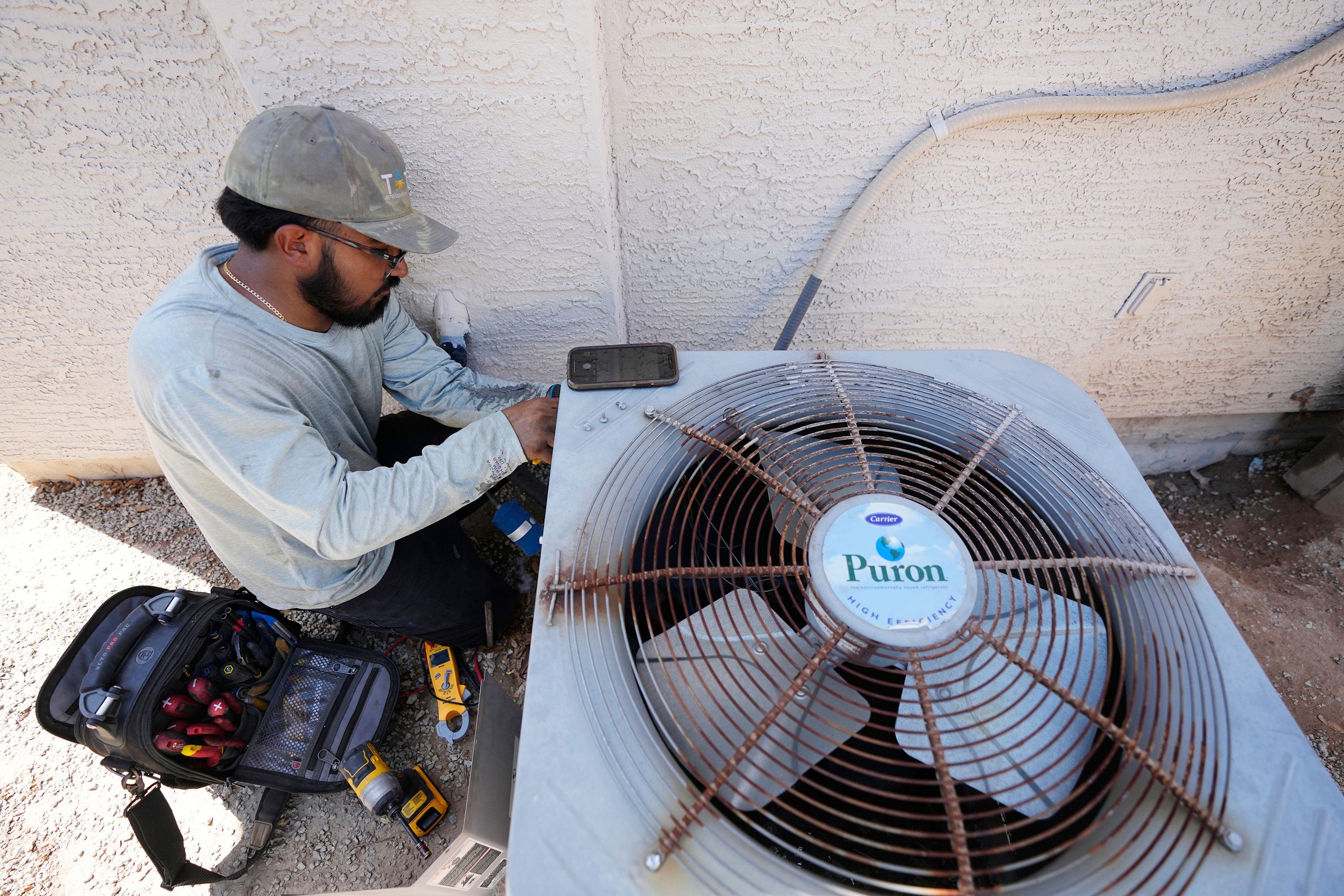 Total Refrigeration service tech Michael Villa works on replacing a fan motor on an air conditioning unit