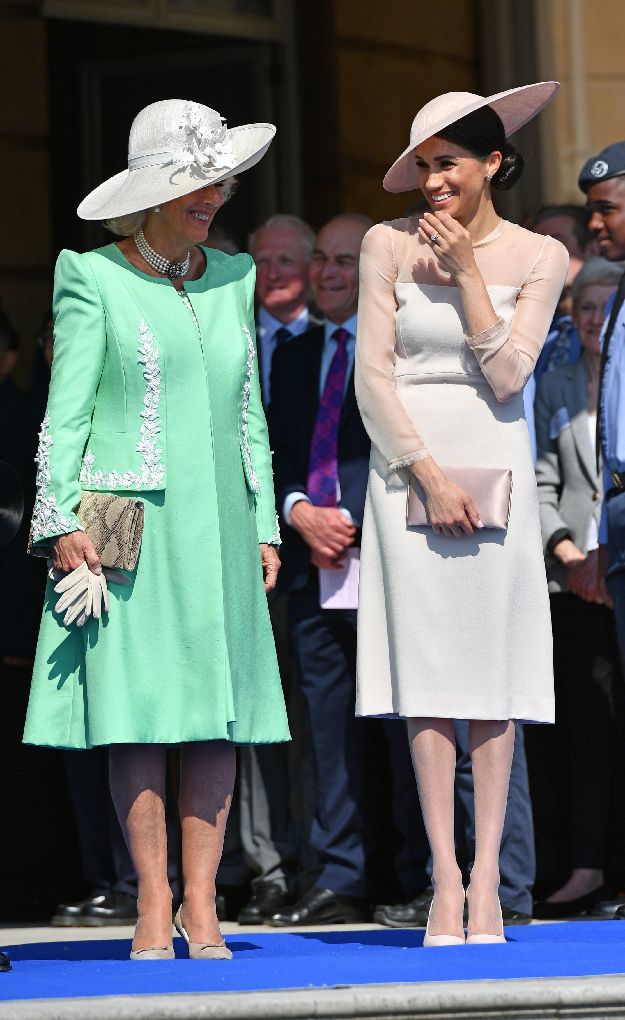 Queen Camilla with the Duchess of Sussex, in nude tights, at a garden party at Buckingham Palace shortly after her 2018 wedding