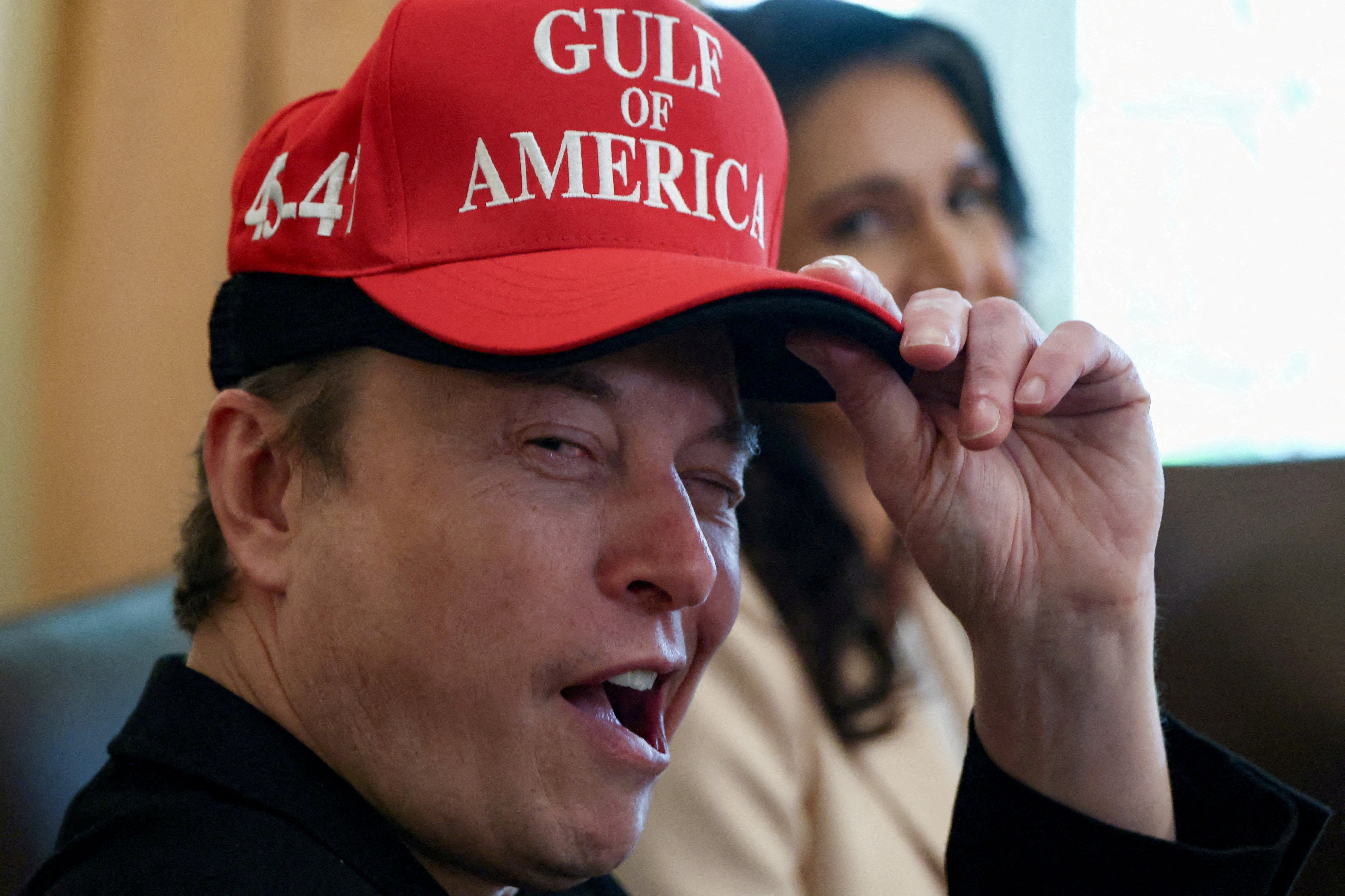 Tesla CEO Elon Musk reacts while wearing a cap with the words "Gulf of America" as he attends a cabinet meeting held by U.S. President Donald Trump at the White House in Washington in April 2025