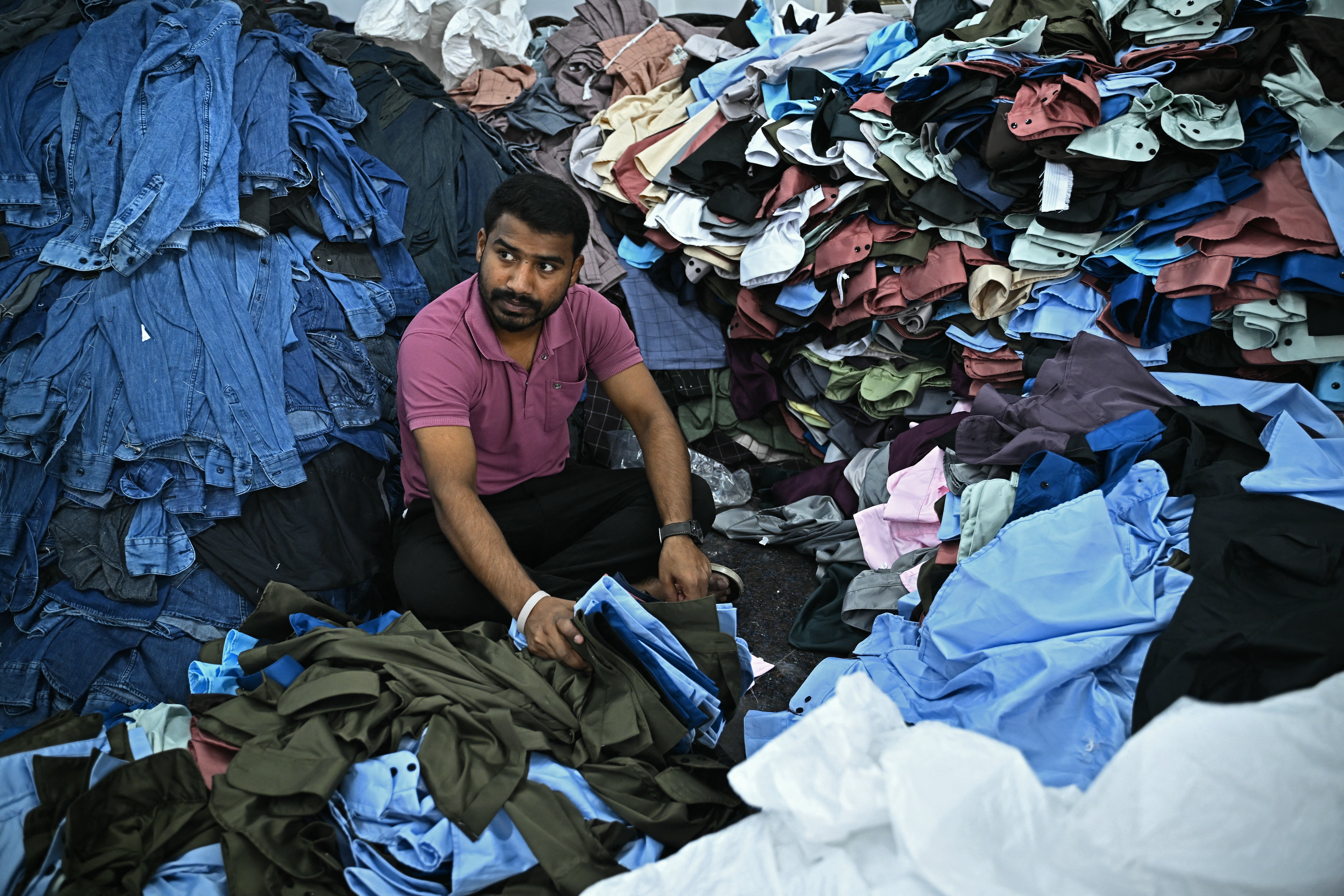 A garment worker sorts tailored shirts and denim jeans at an apparel manufacturing unit in Bengaluru on 25 August 2025
