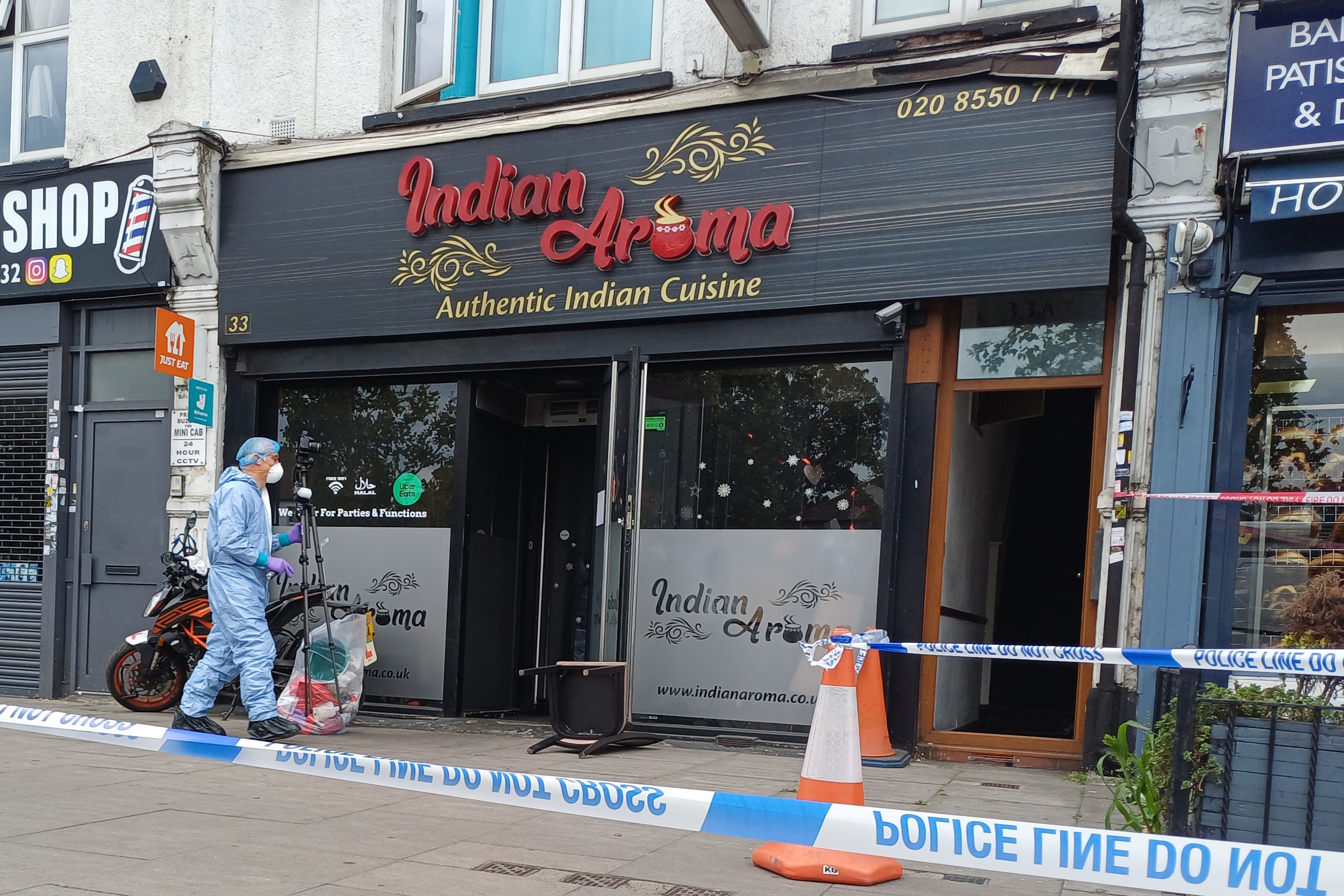 A forensic investigator at a restaurant in Ilford, east London (Helen William/PA)