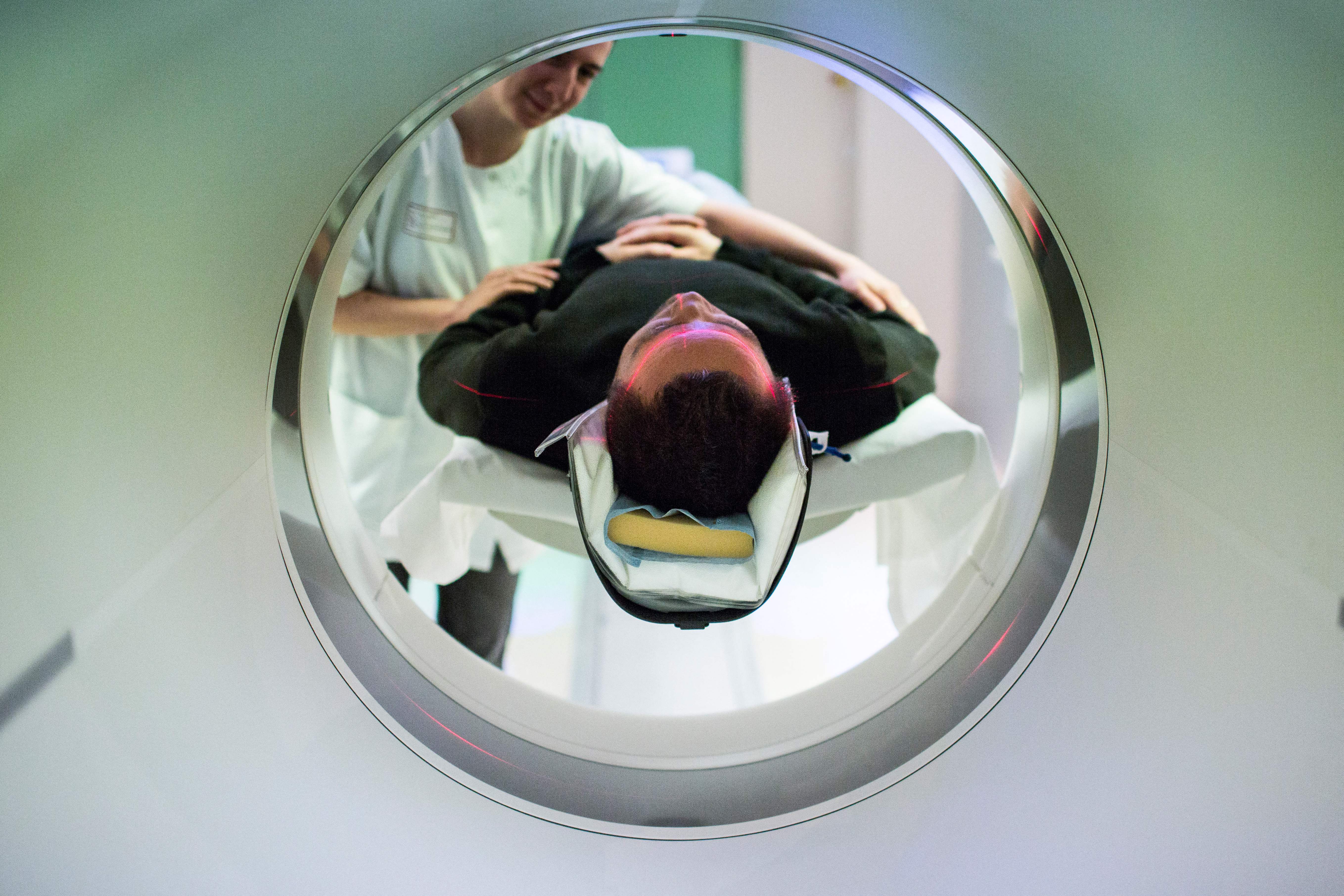 A patient enters a CT scanner. The entire coronary calcium scan, done in a machine like this, takes around 10 to 15 minutes