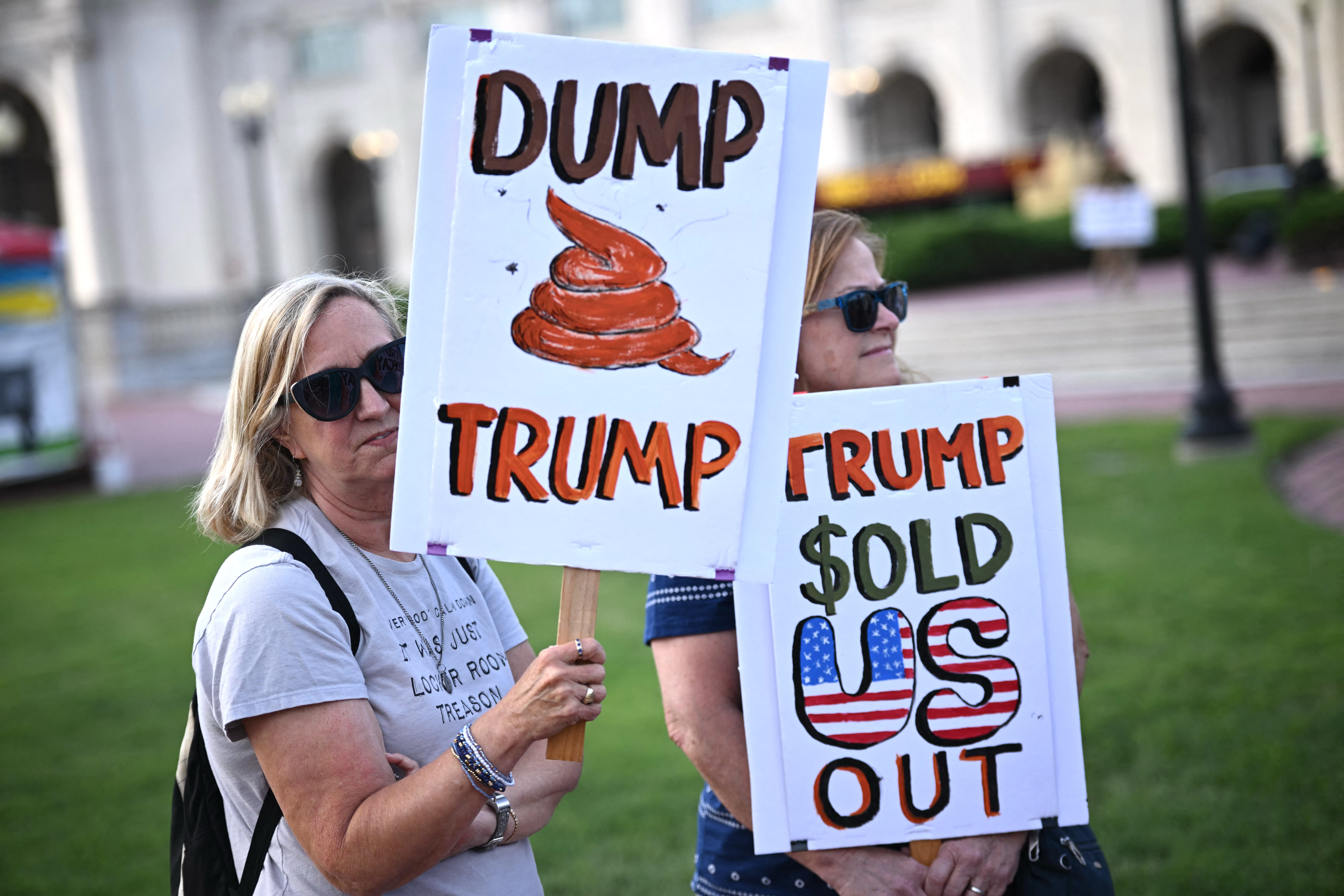 Activists hold signs as they rally during a ‘Rage Against the Regime’ protest in front of Union Station in Washington, D.C. on August 2