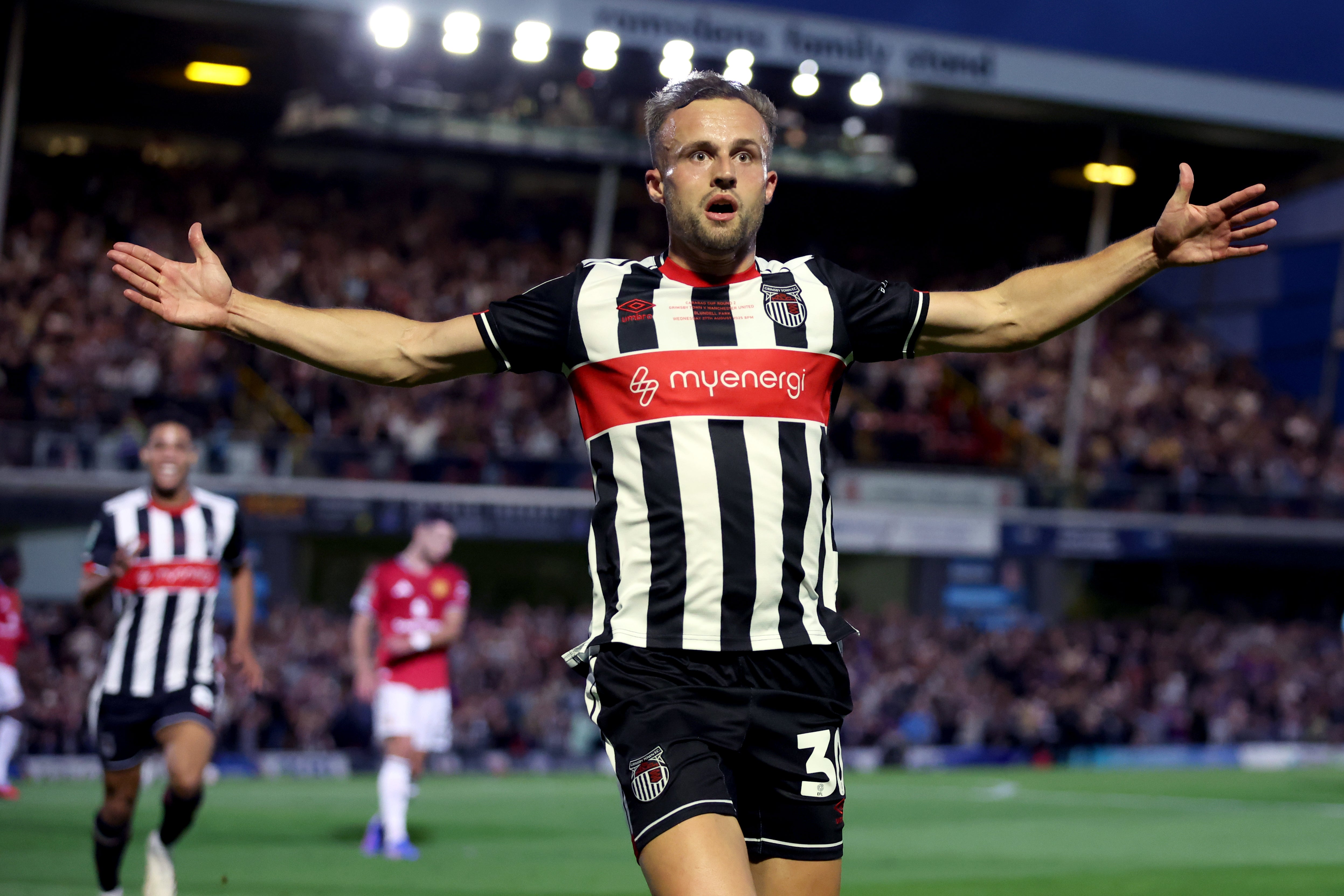 Charles Vernam celebrates his opener for Grimsby against Manchester United