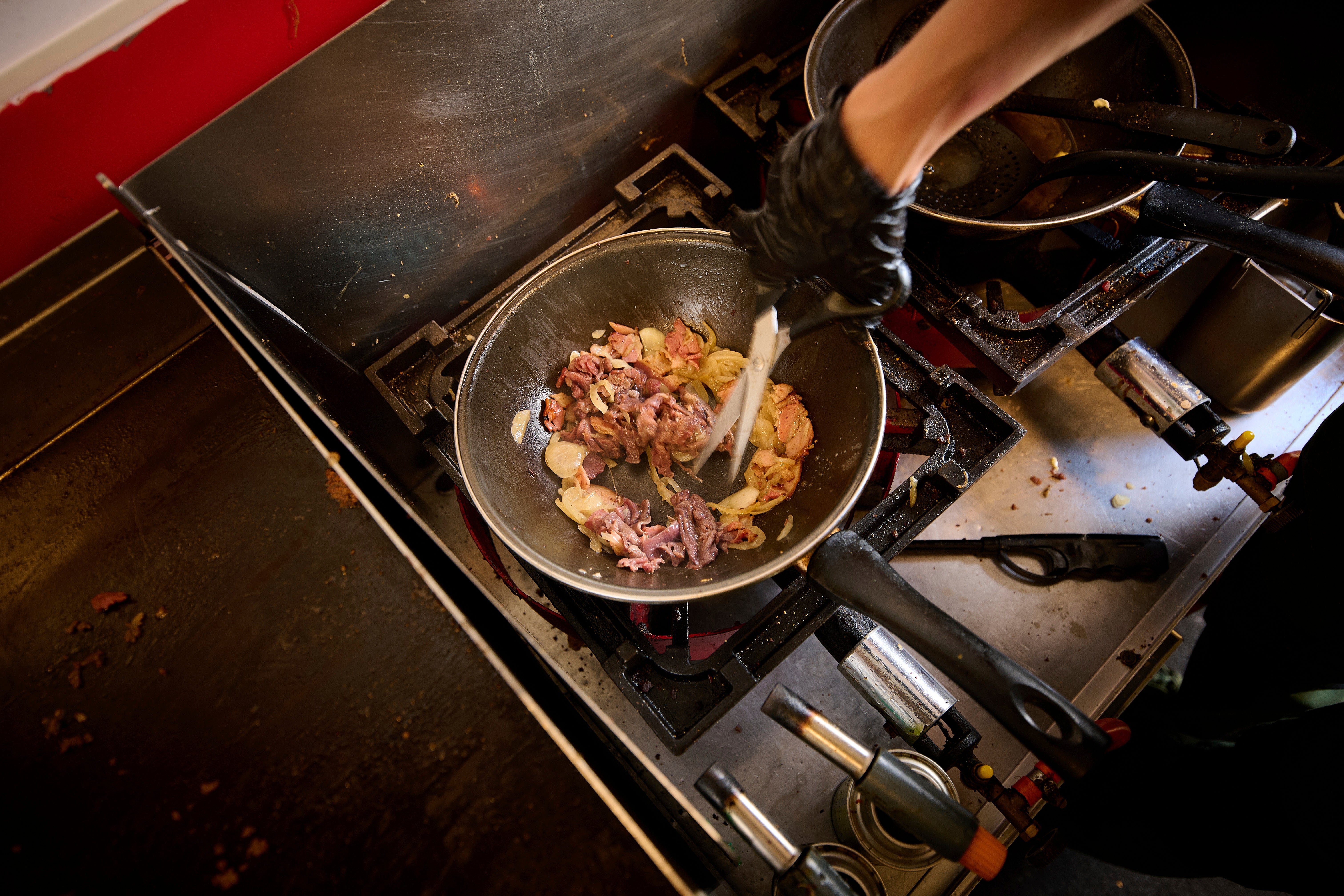 A person cooks inside the Stejk Street Food truck in Kiruna